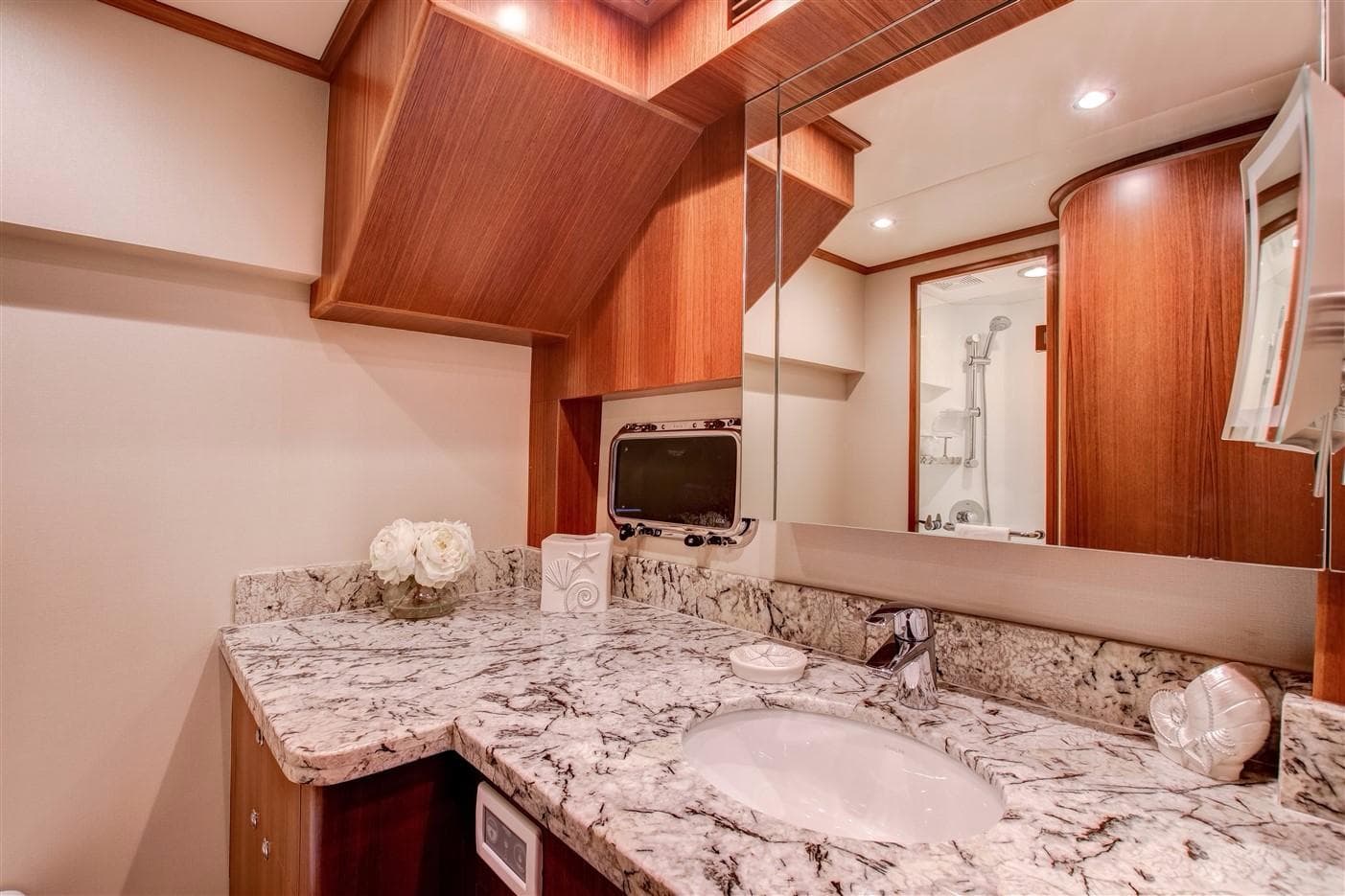 Luxurious bathroom in 2027 Outer Reef Yachts 610 Motoryacht with marble countertop and elegant wood finish.