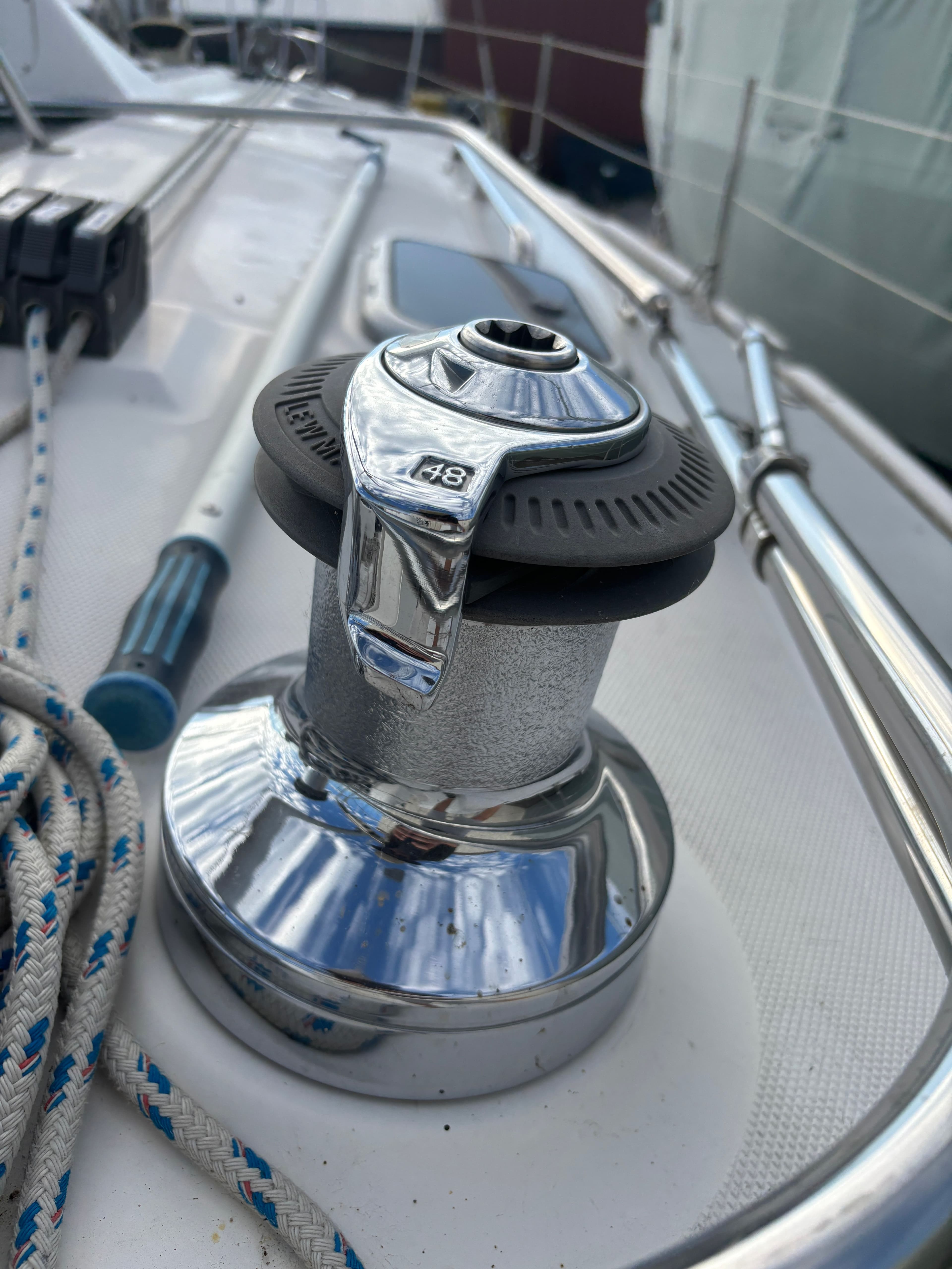 Chrome winch on 2001 Hunter 460 sailboat deck with ropes and railing.