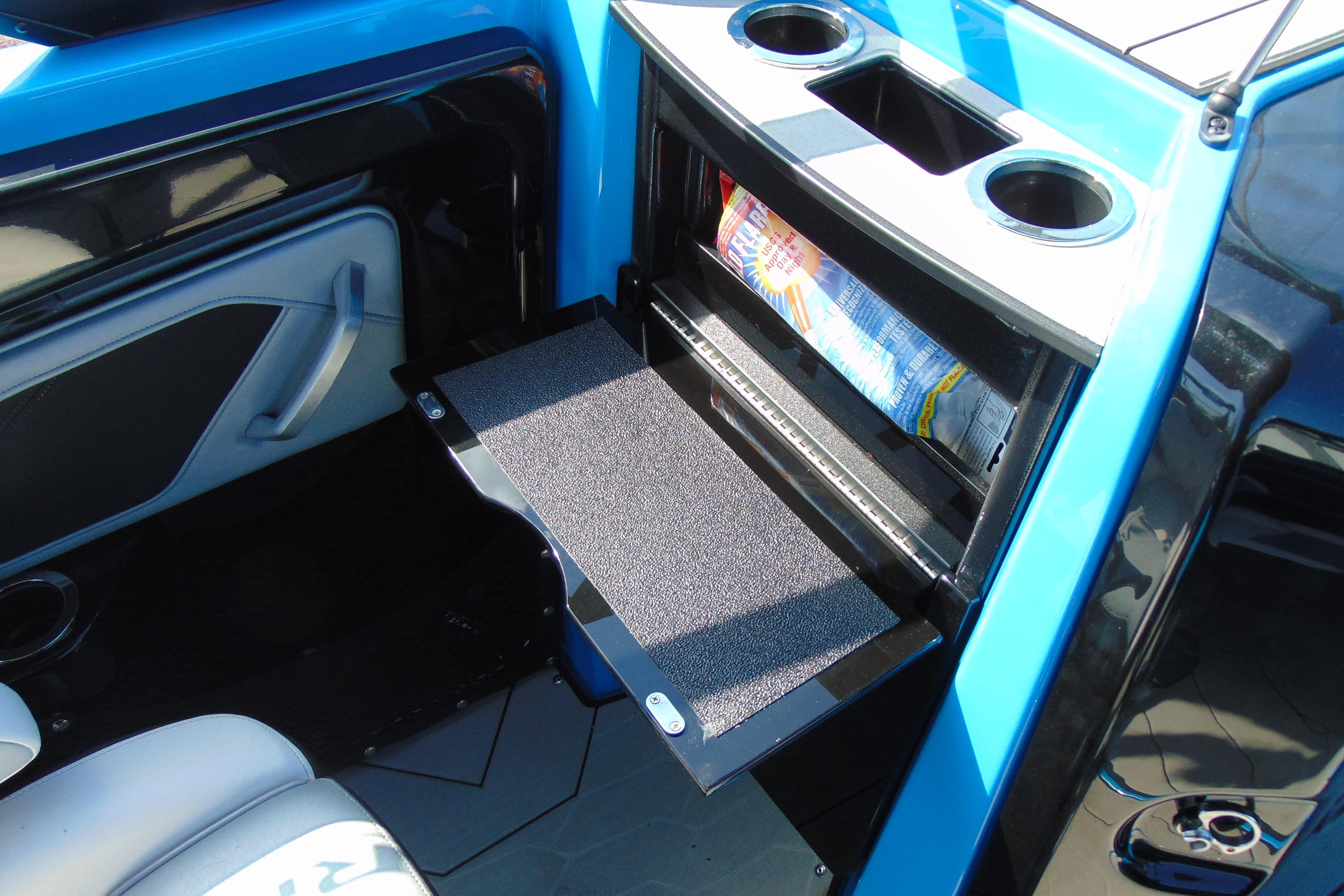 2022 Yamaha Boats 255XD interior storage compartment with cup holders and open shelf.