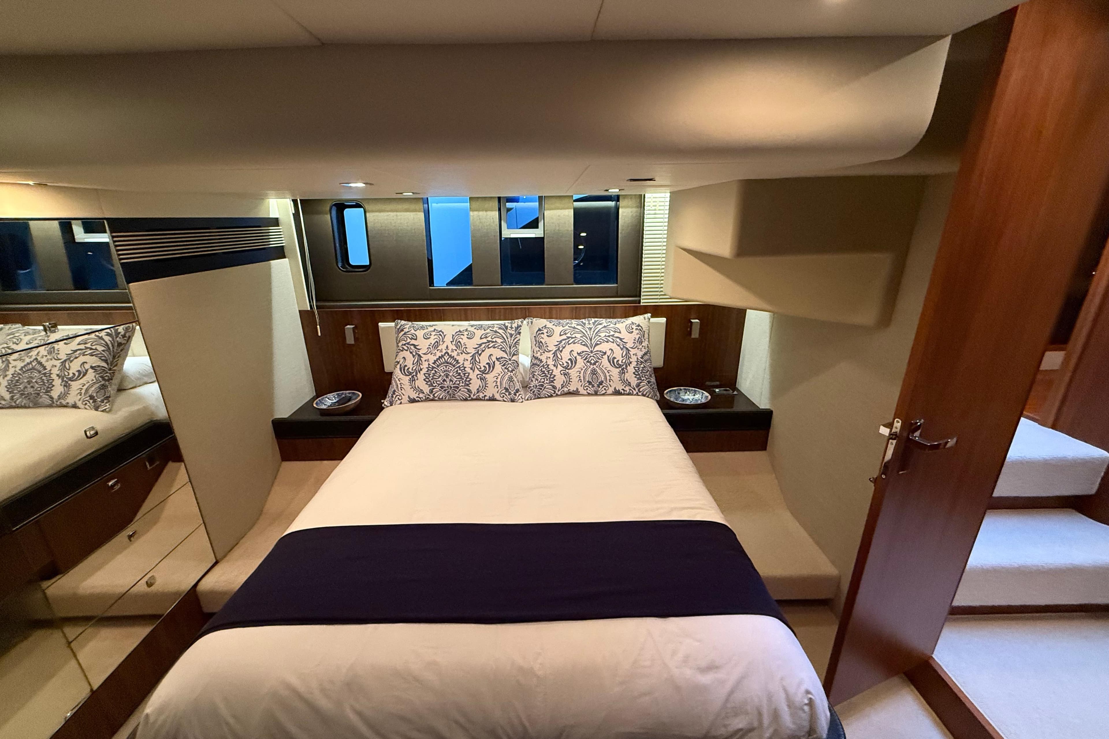 Luxurious bedroom interior of 2012 Fairline Squadron 58 yacht with elegant bedding and wood accents.