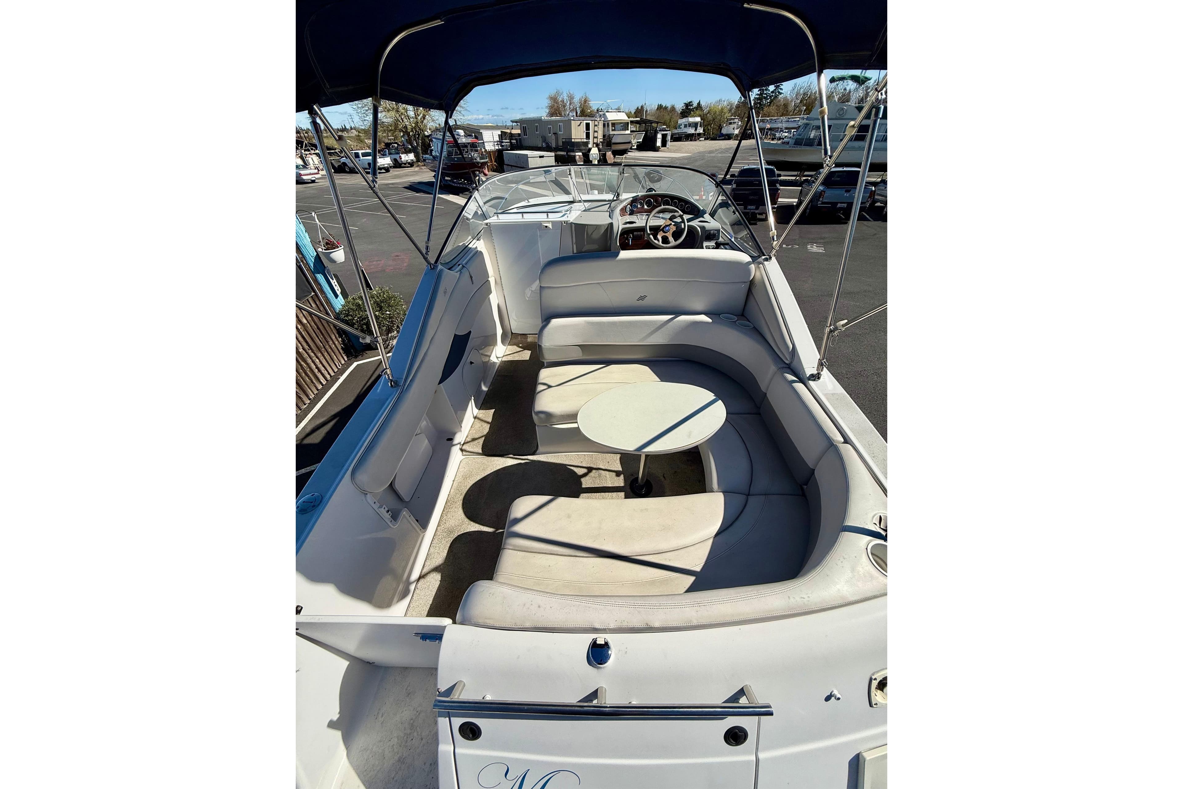 2000 Four Winns 288 Vista boat interior with seating and table, docked outdoors.