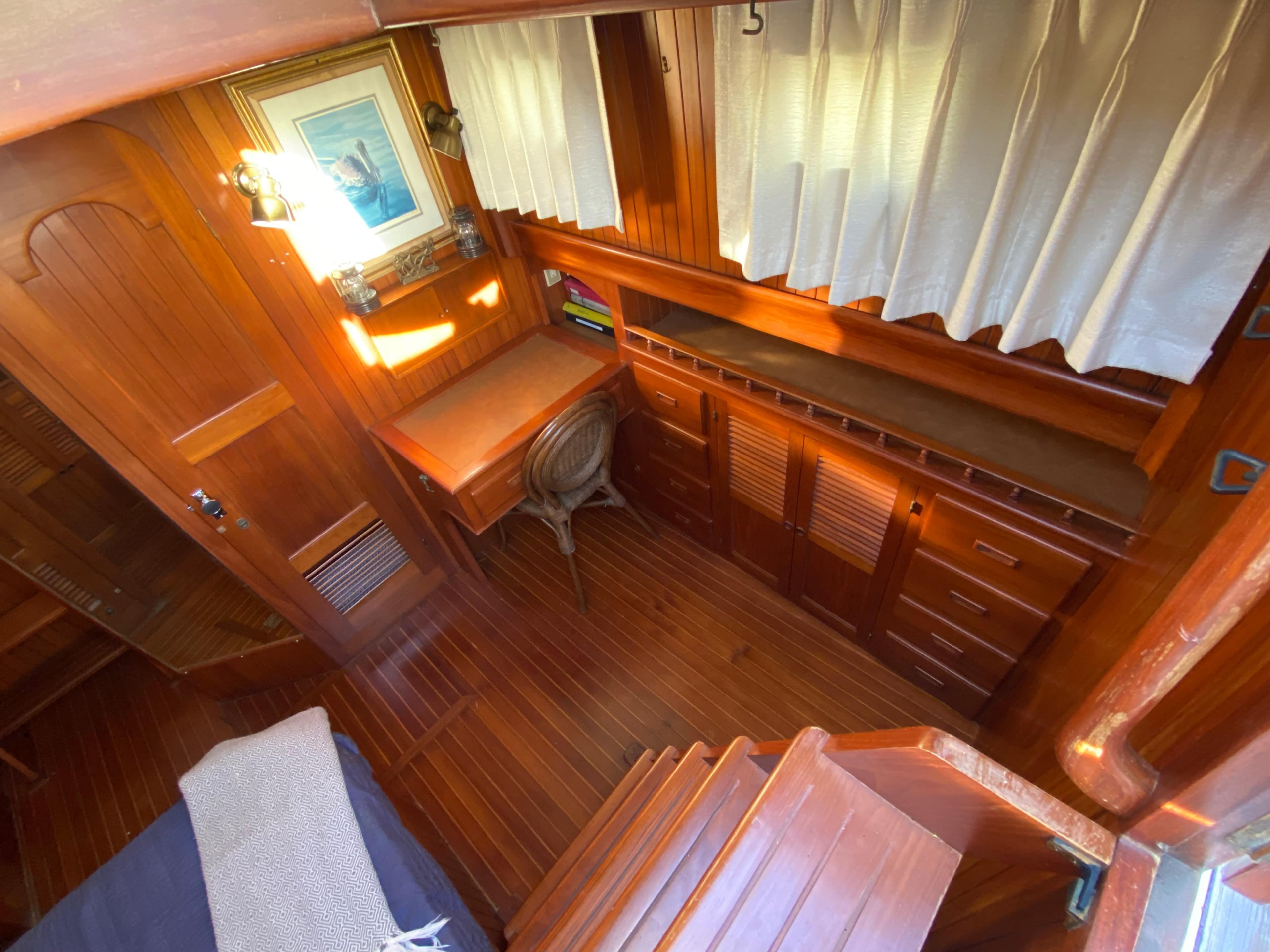 1983 DeFever 41 yacht interior with wooden furnishings and desk area.