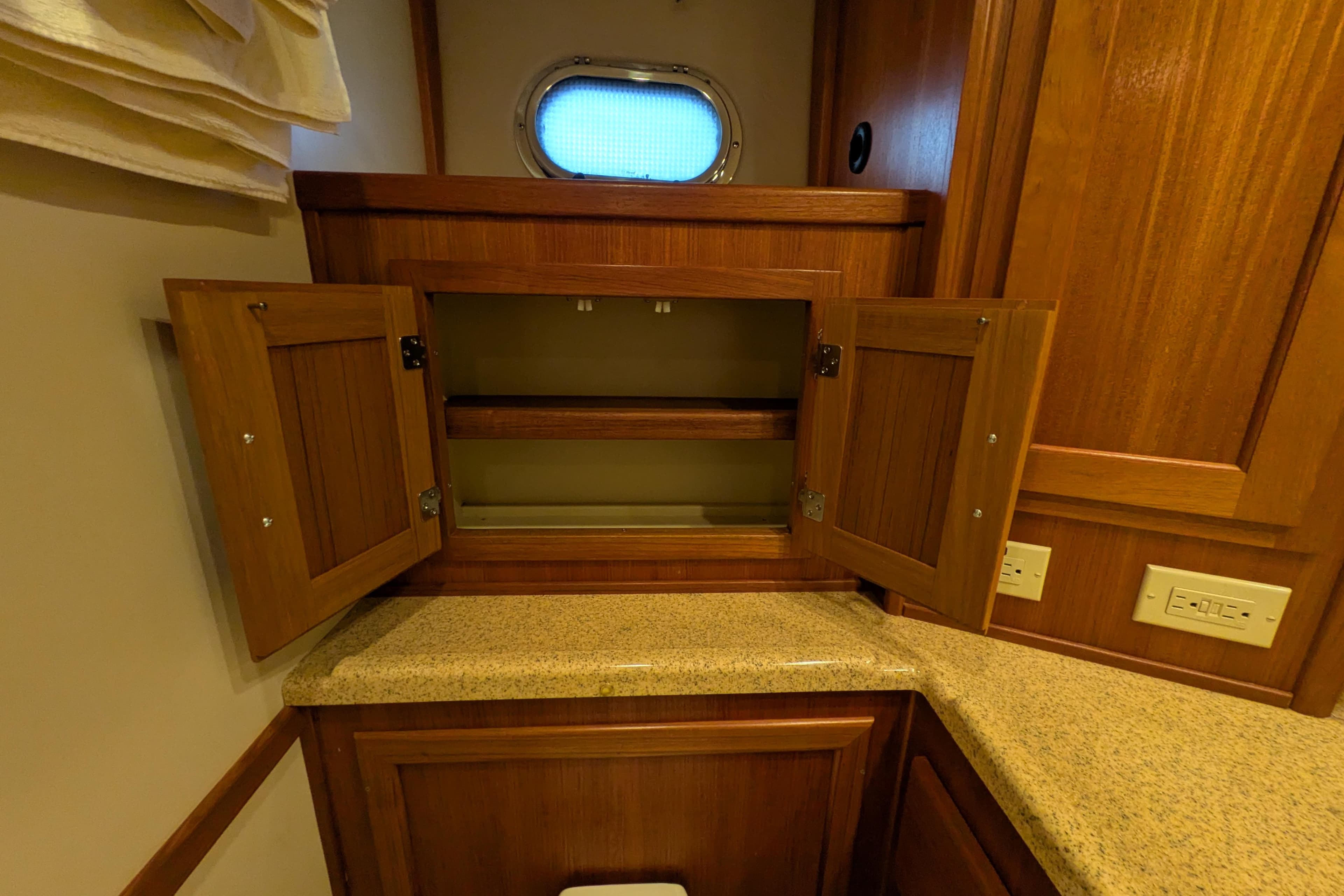 Interior of 2005 American Tug 41 with open wooden cabinet and countertop.