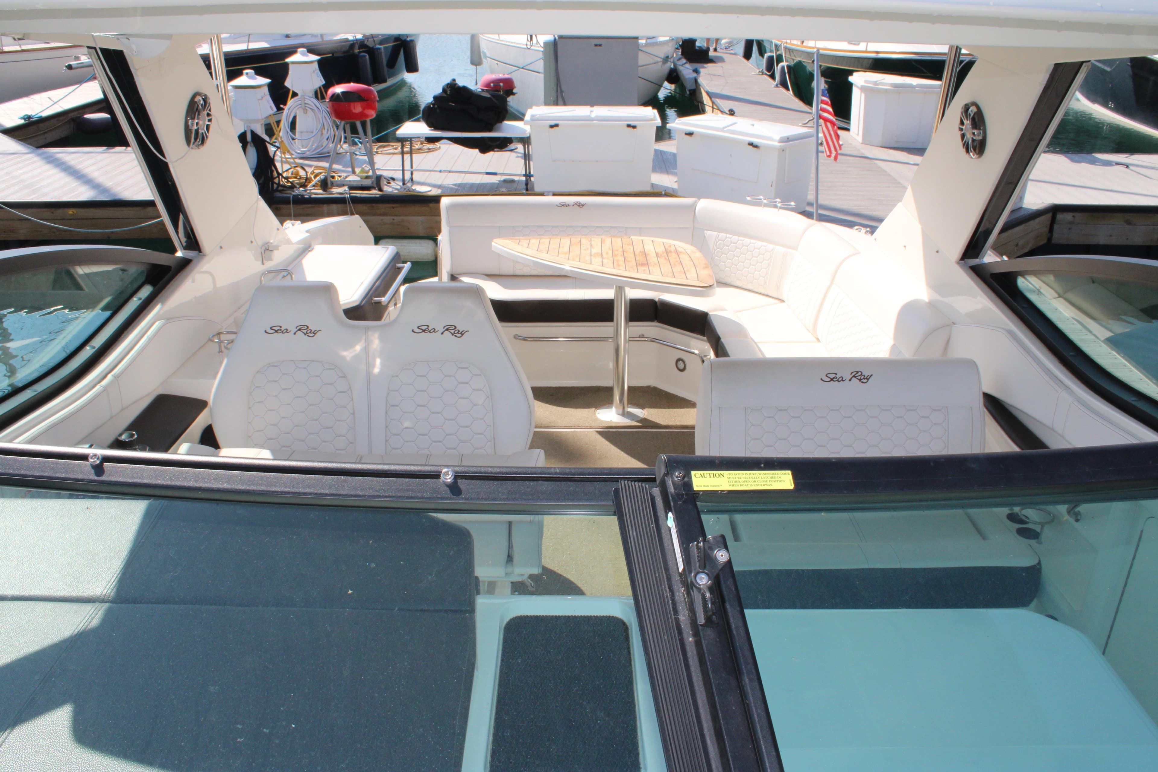 2019 Sea Ray Sundancer 320 interior with white seating and wooden table.