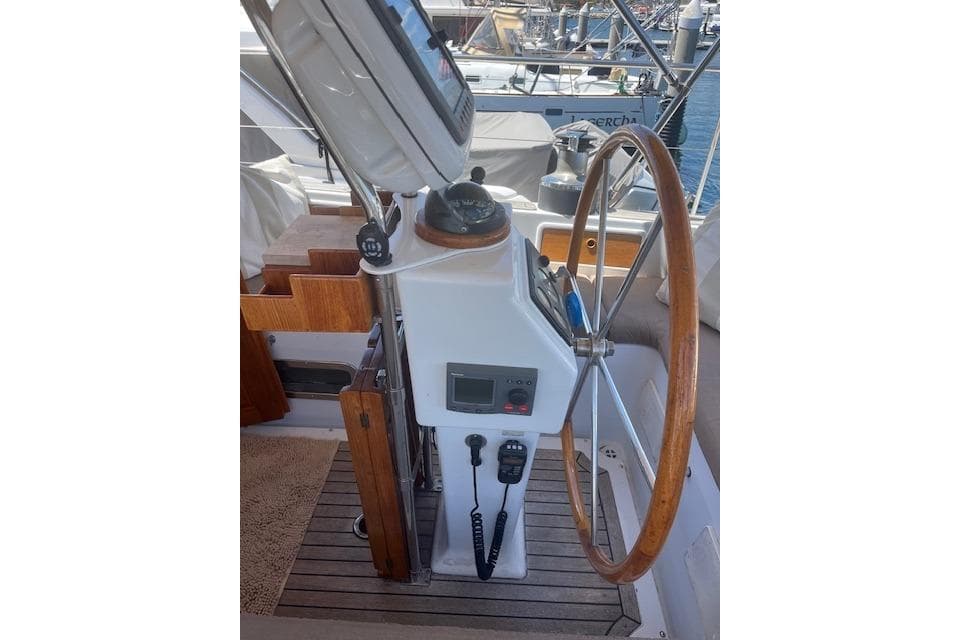 Helm of 1986 Liberty 49 sailboat with wooden wheel and navigation equipment.