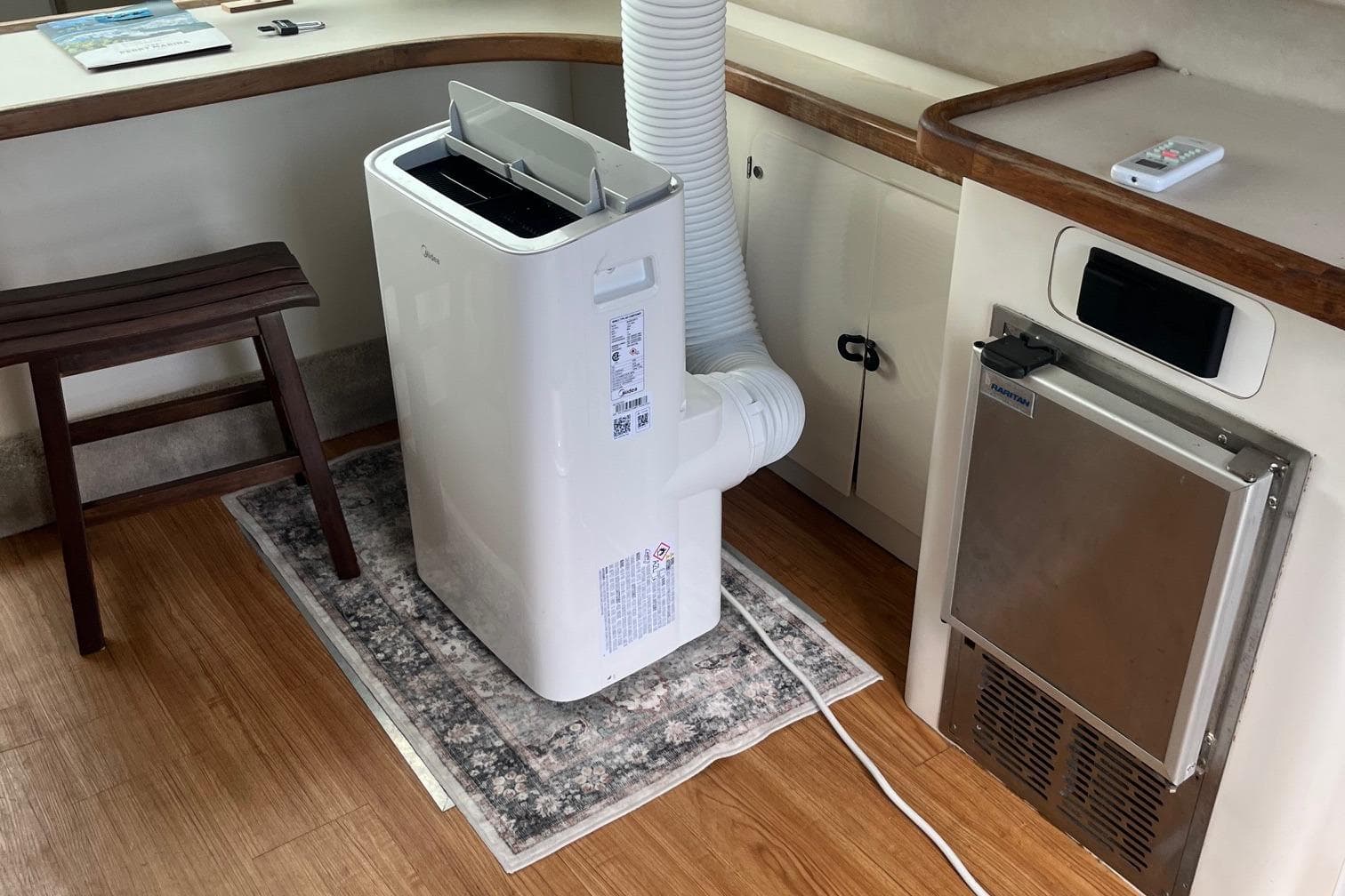 Portable air conditioner on a 1996 Sea Ray 370 Sedan Bridge yacht interior.