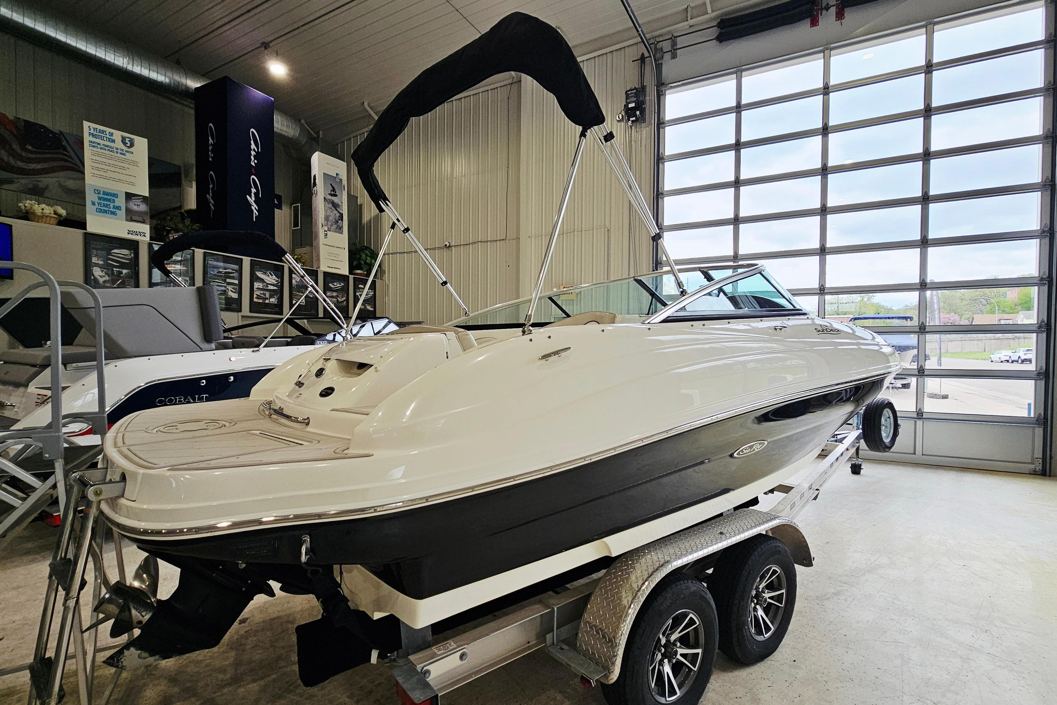 2012 Sea Ray 200 Sundeck boat on trailer in showroom.