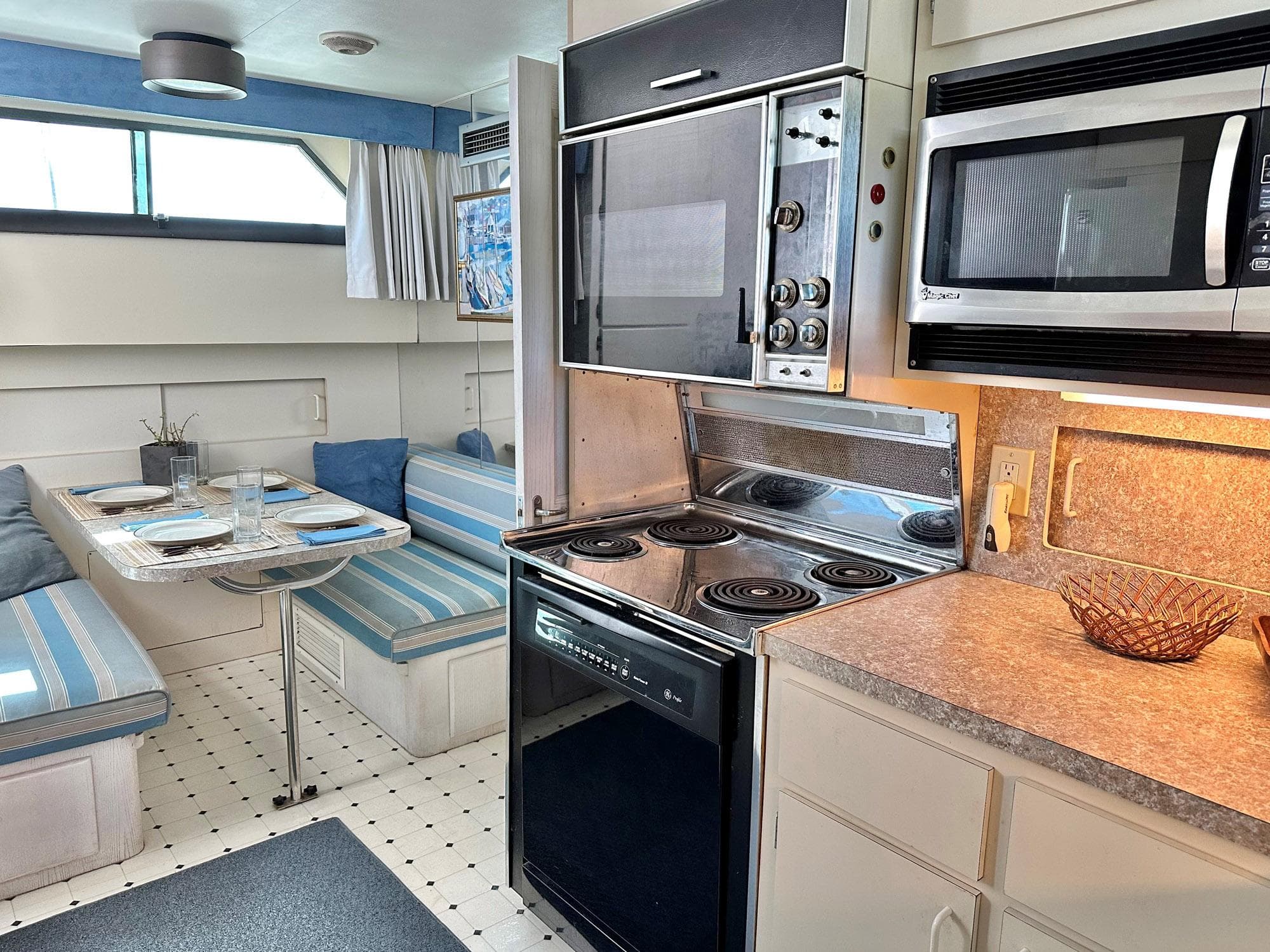 Interior of 1987 Hatteras 54 Motoryacht with kitchen and dining area, featuring modern appliances.