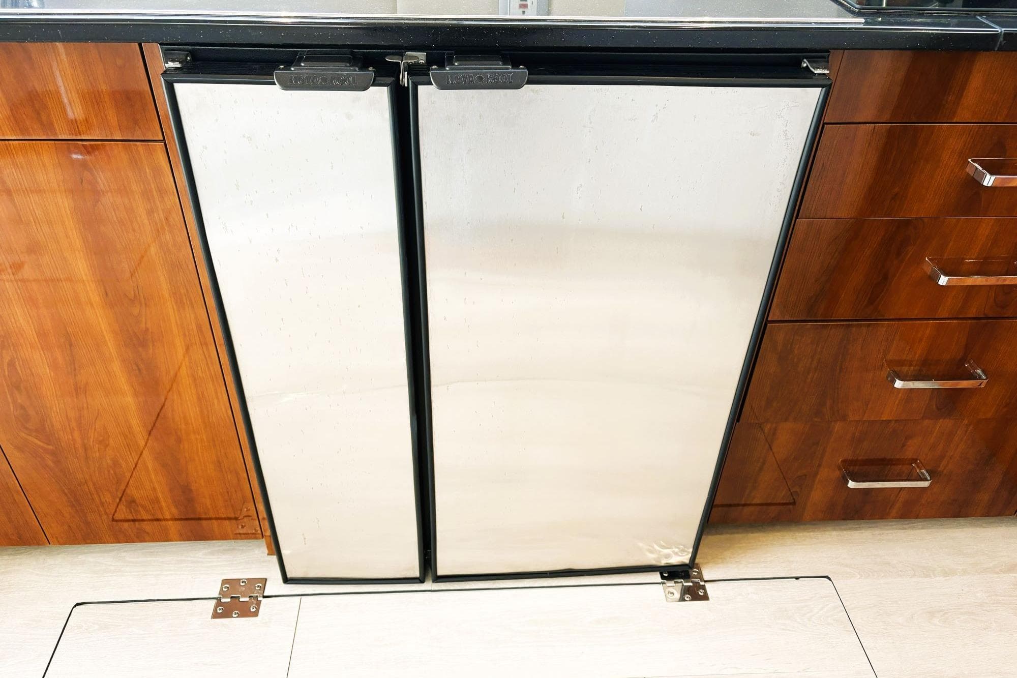 Stainless steel refrigerator in 2016 Carver C40 yacht kitchen with wooden cabinetry.