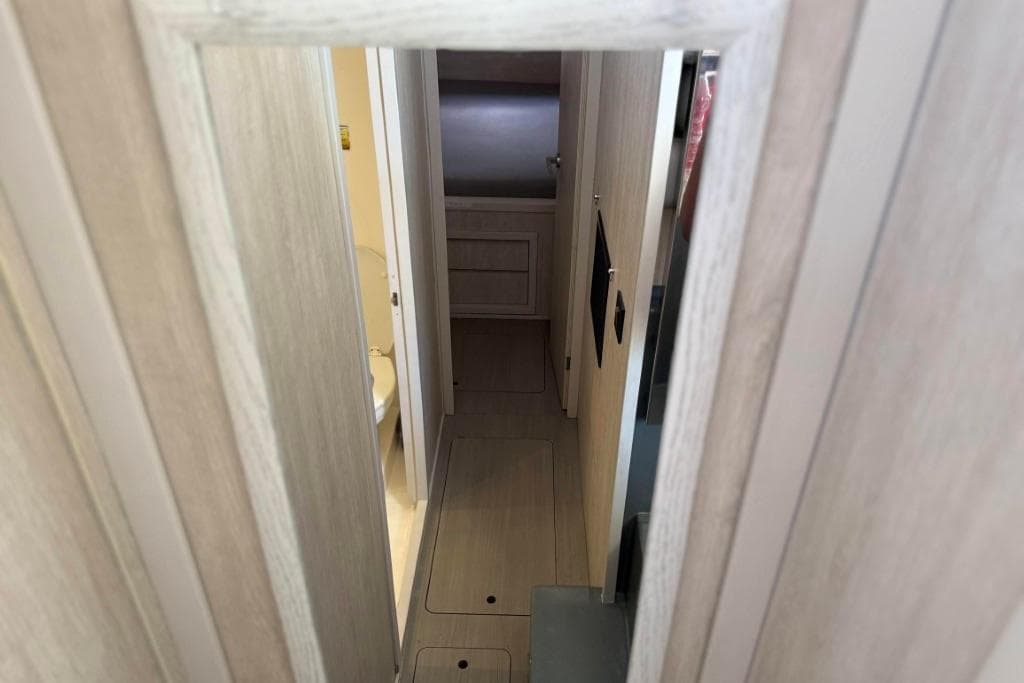 Narrow hallway inside 2016 Leopard 404 yacht, featuring light wood paneling and compact design.
