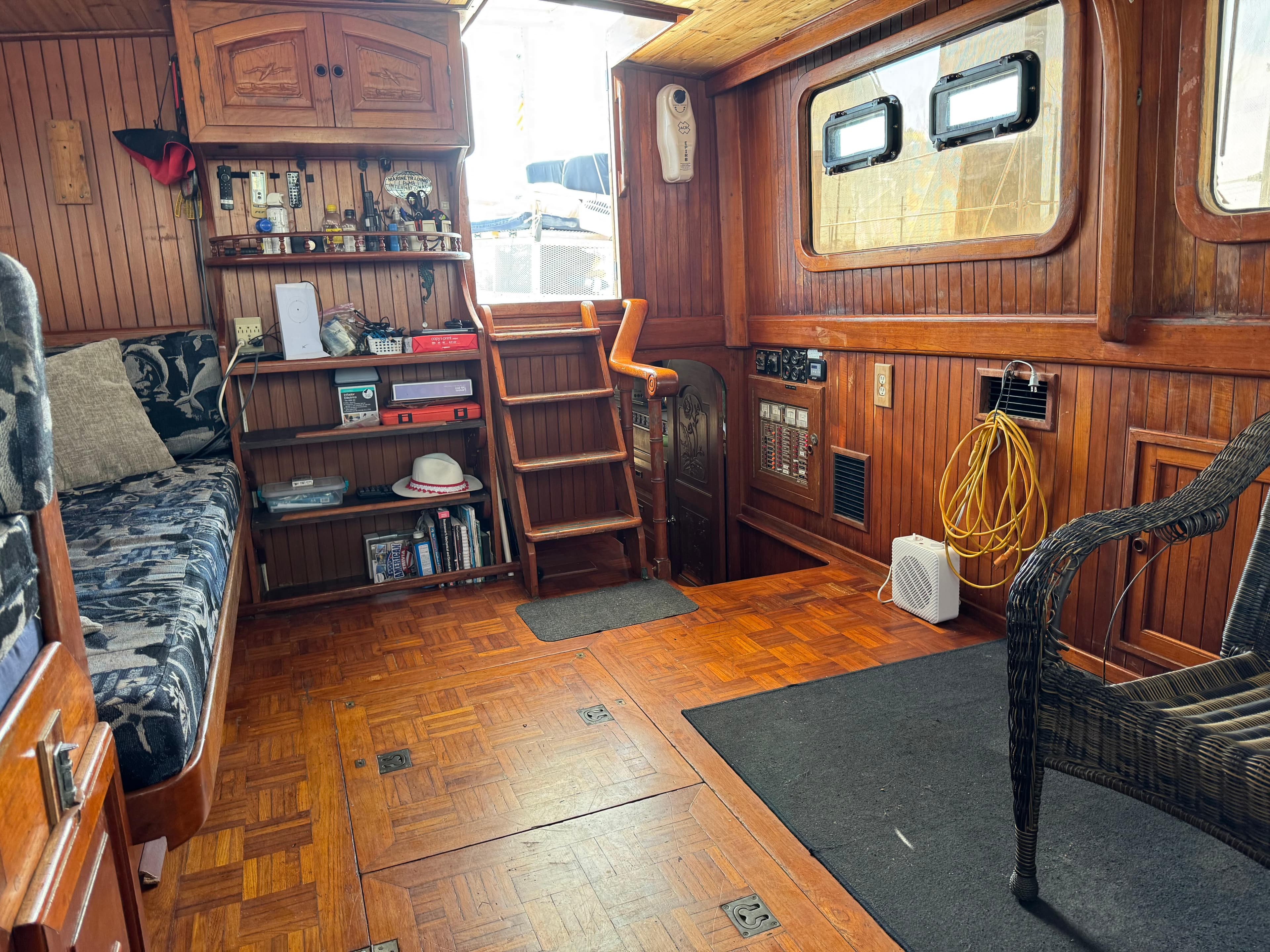 Interior of 1983 Island Trader Motor Sailor with wooden decor and cozy seating area.