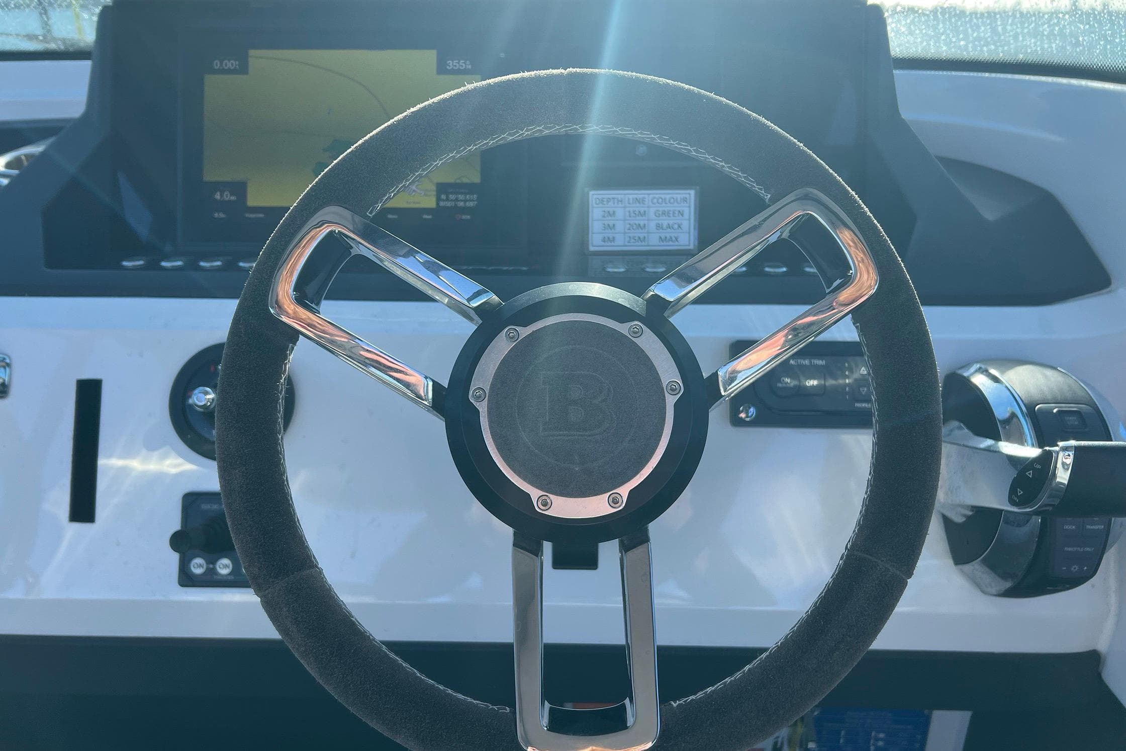 Steering wheel of 2019 Axopar 28 T-Top boat with dashboard controls.