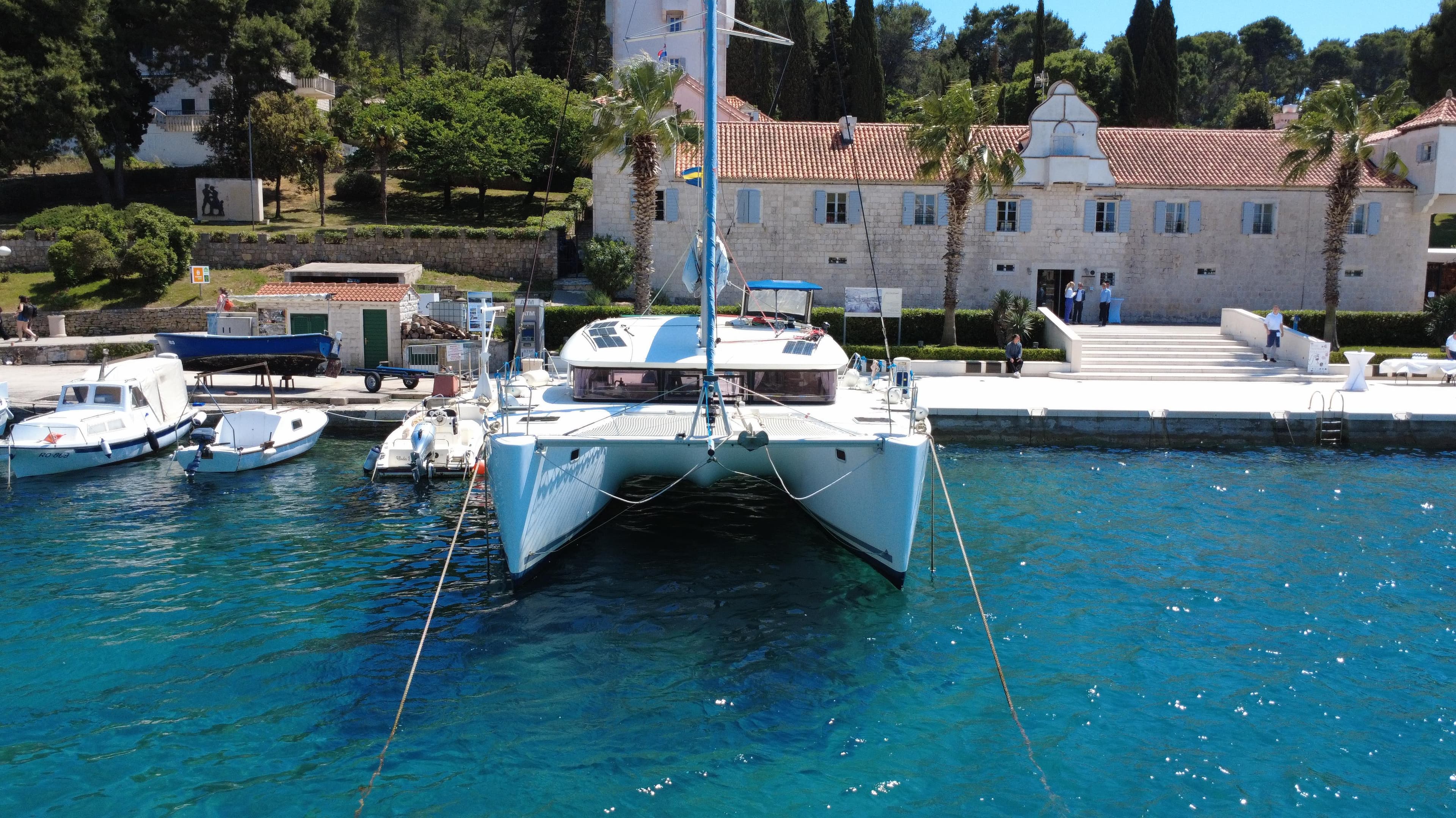 2017 Lagoon 400 S2 catamaran docked at a scenic marina with clear blue water.