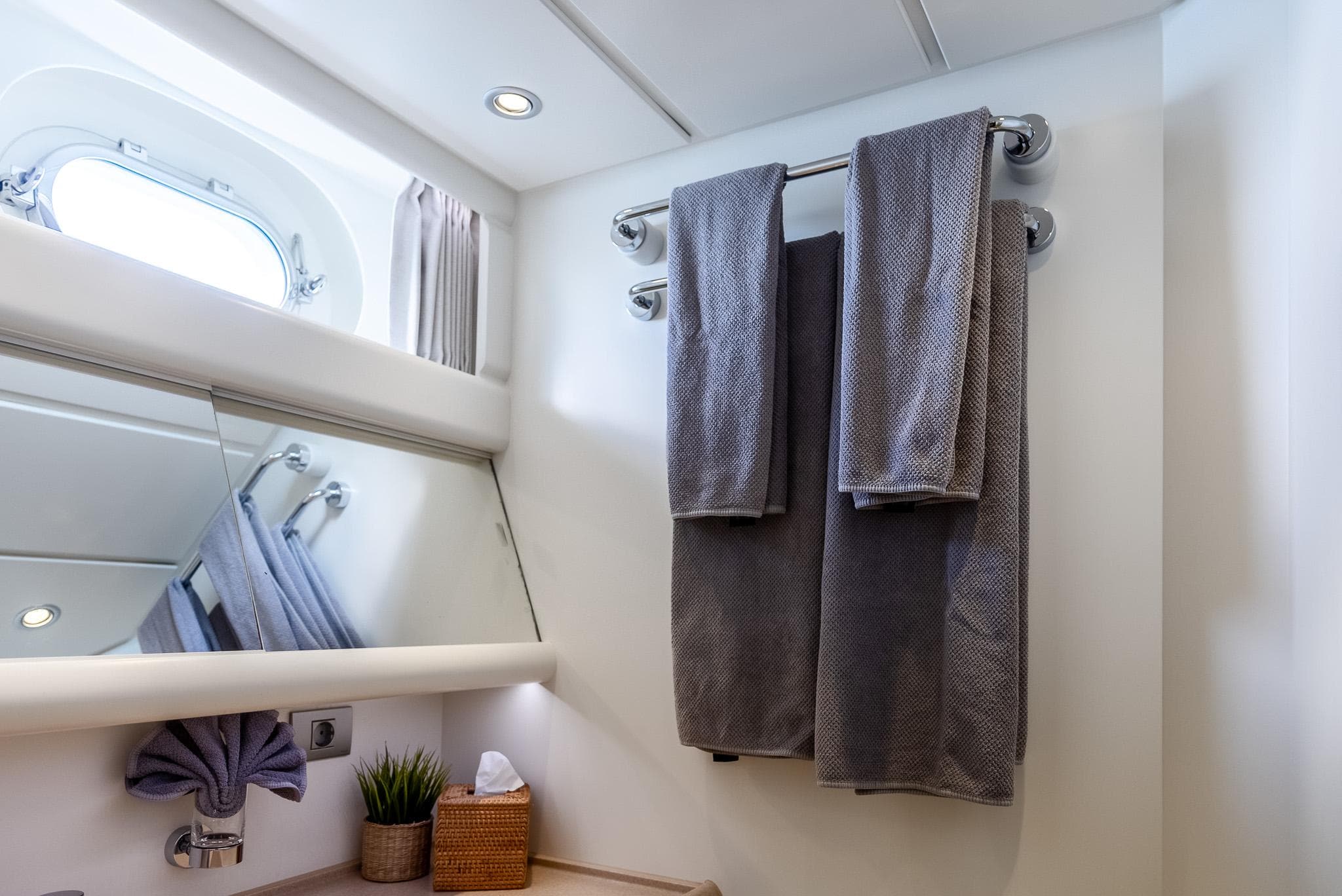 Luxury bathroom on 2005 Jongert 2900M yacht with towels and porthole window.