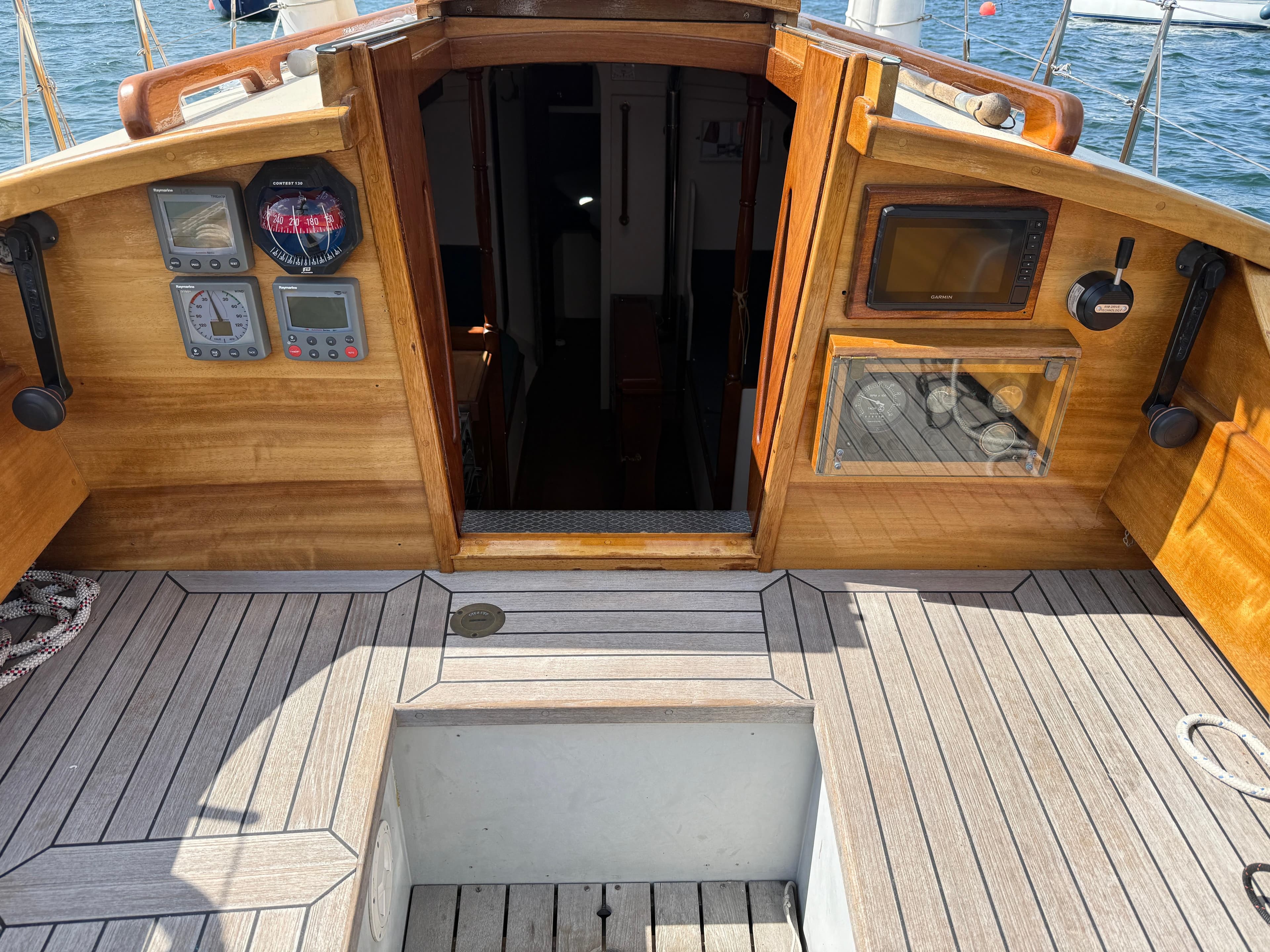 Cockpit of 2010 Buccaneer Salcombe Trader 27 with navigation instruments and wooden finish.