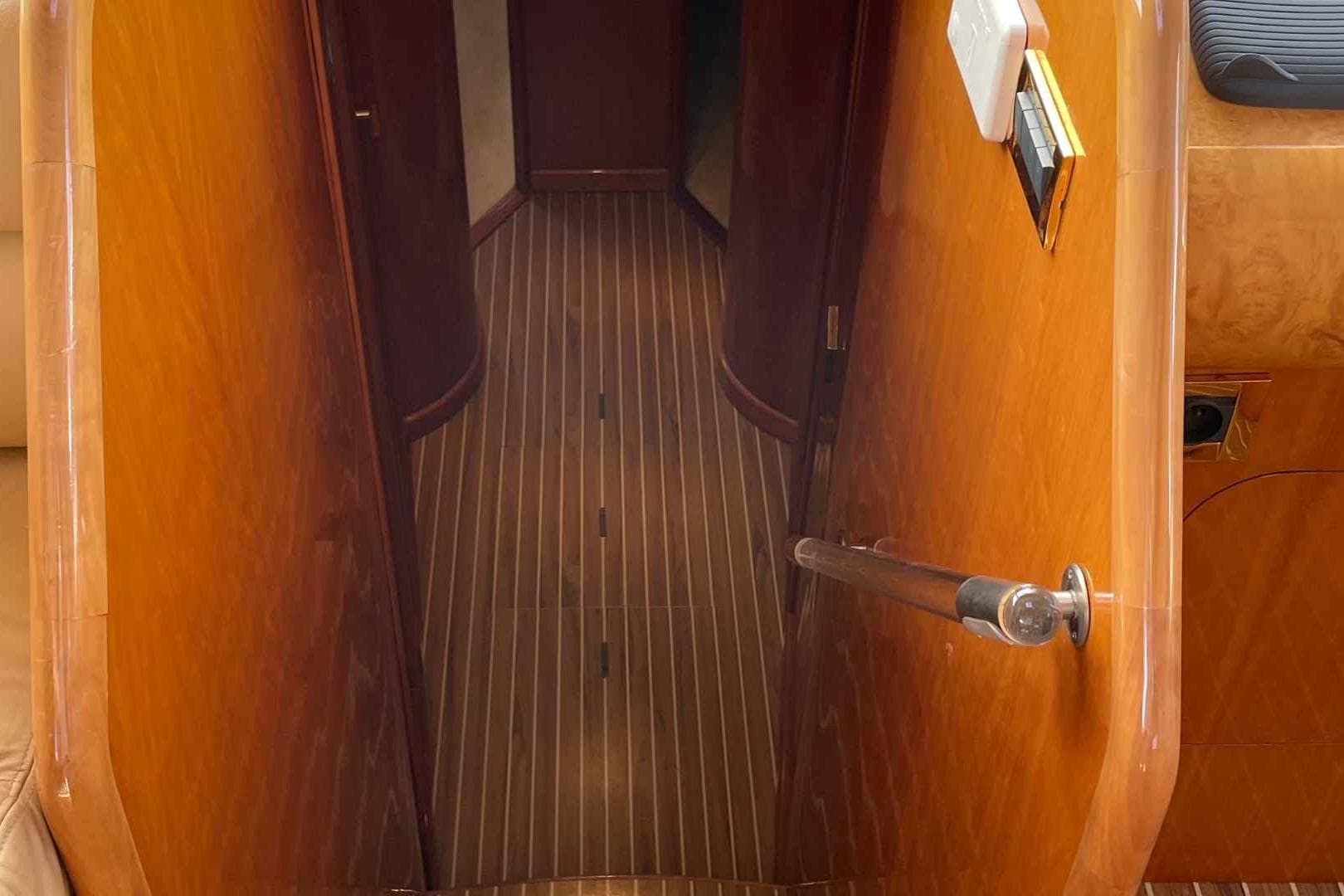 Interior hallway of 1998 Guy Couach 2100 yacht with wooden finish.