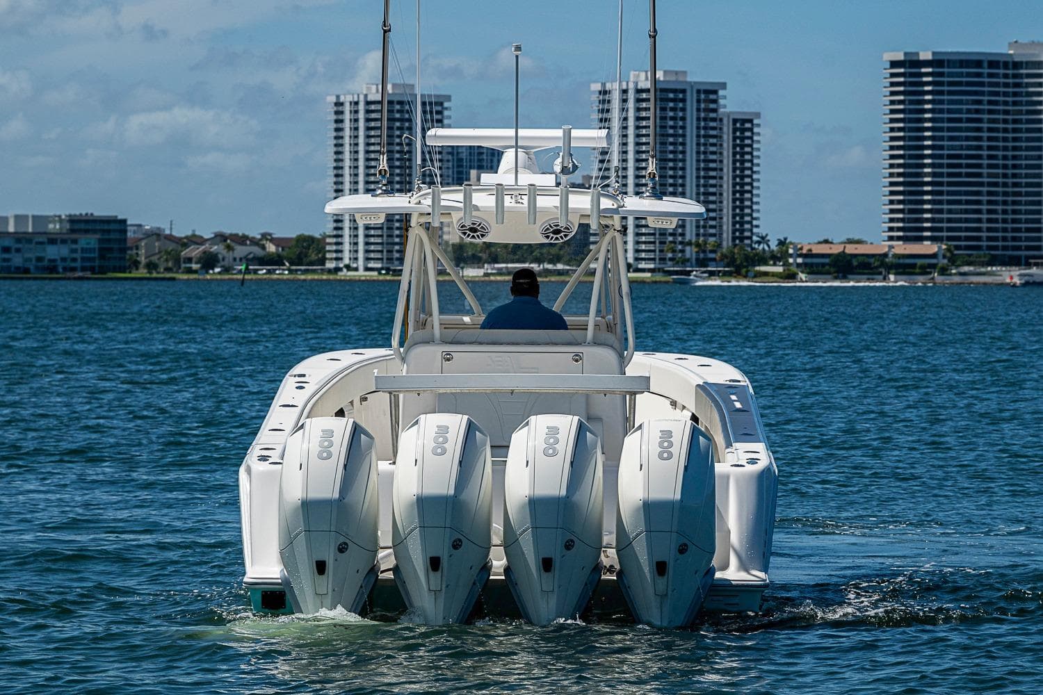 2023 SeaVee 390B boat with four engines cruising near city skyline.