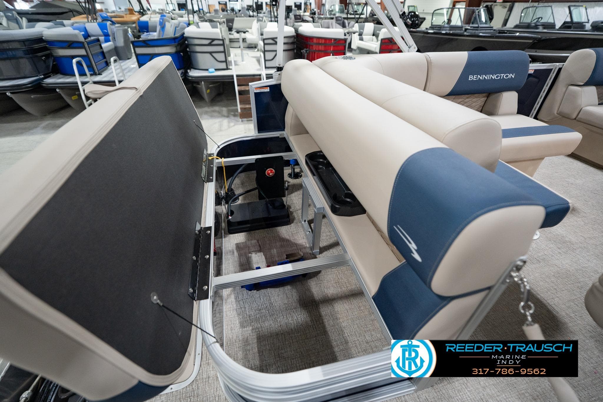 2026 Bennington 168 SLJ pontoon boat interior with storage compartment open in showroom.
