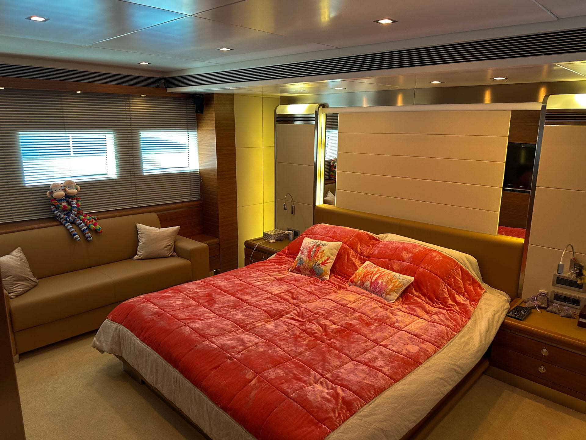 Luxurious bedroom interior on 2012 Avangard Yachts 42M, featuring a plush red bedspread.