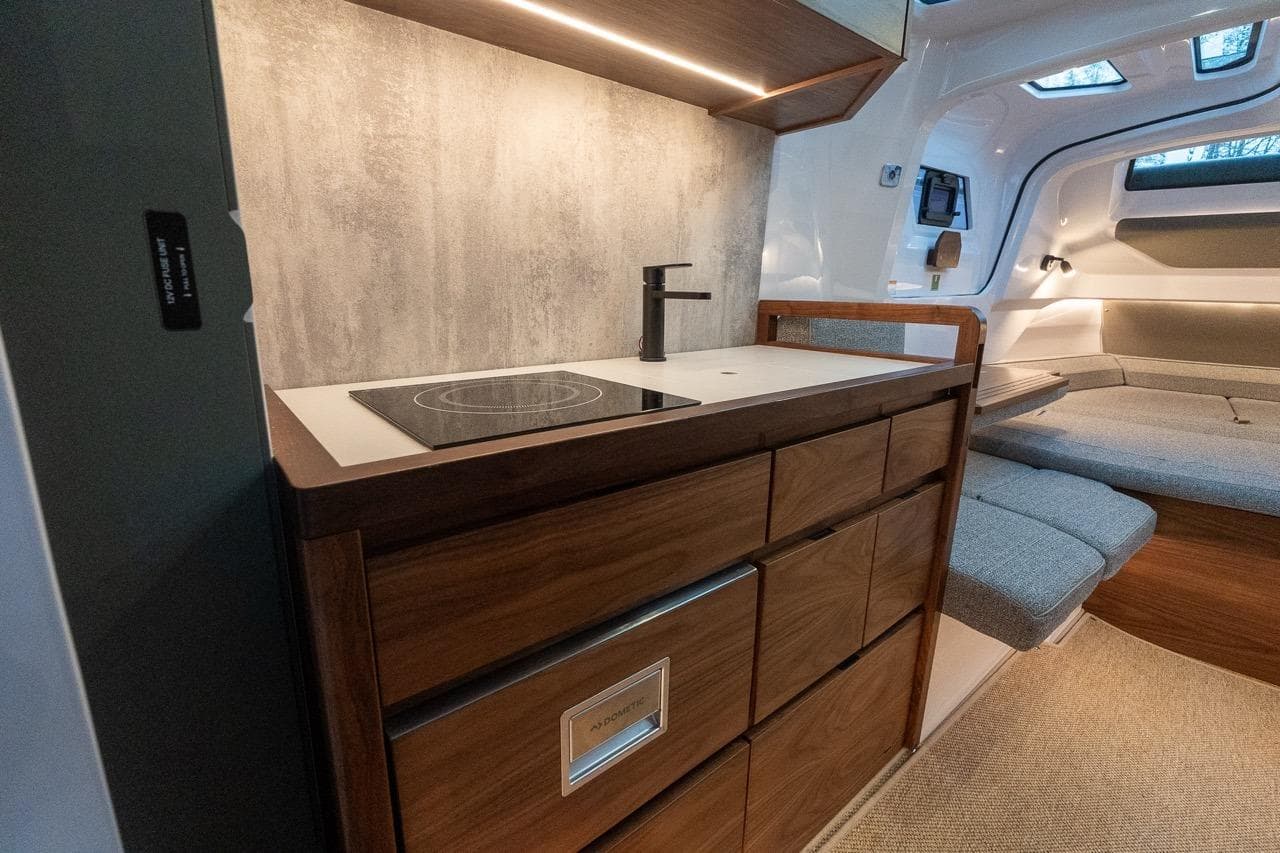 Interior of 2027 Axopar 38 Cross Cabin with modern kitchenette and seating area.