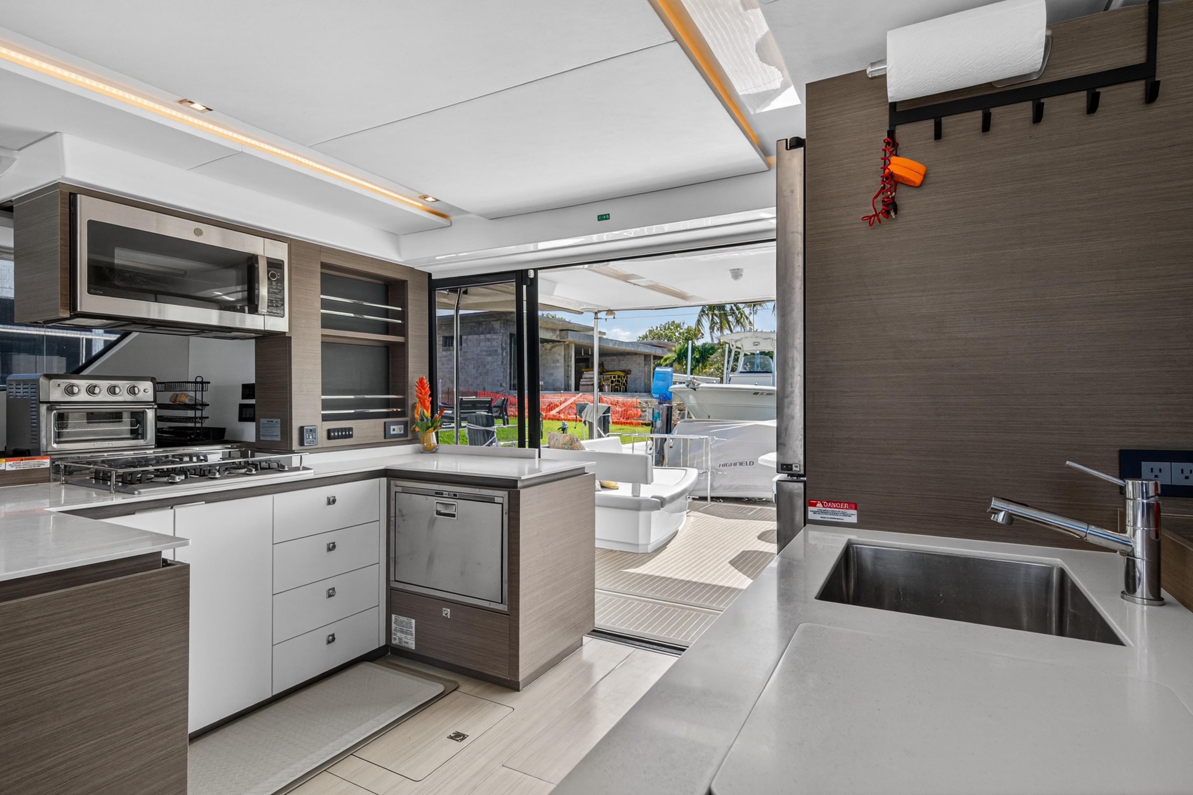 Modern kitchen interior of 2022 Leopard 53 Powercat yacht with sleek appliances and outdoor view.