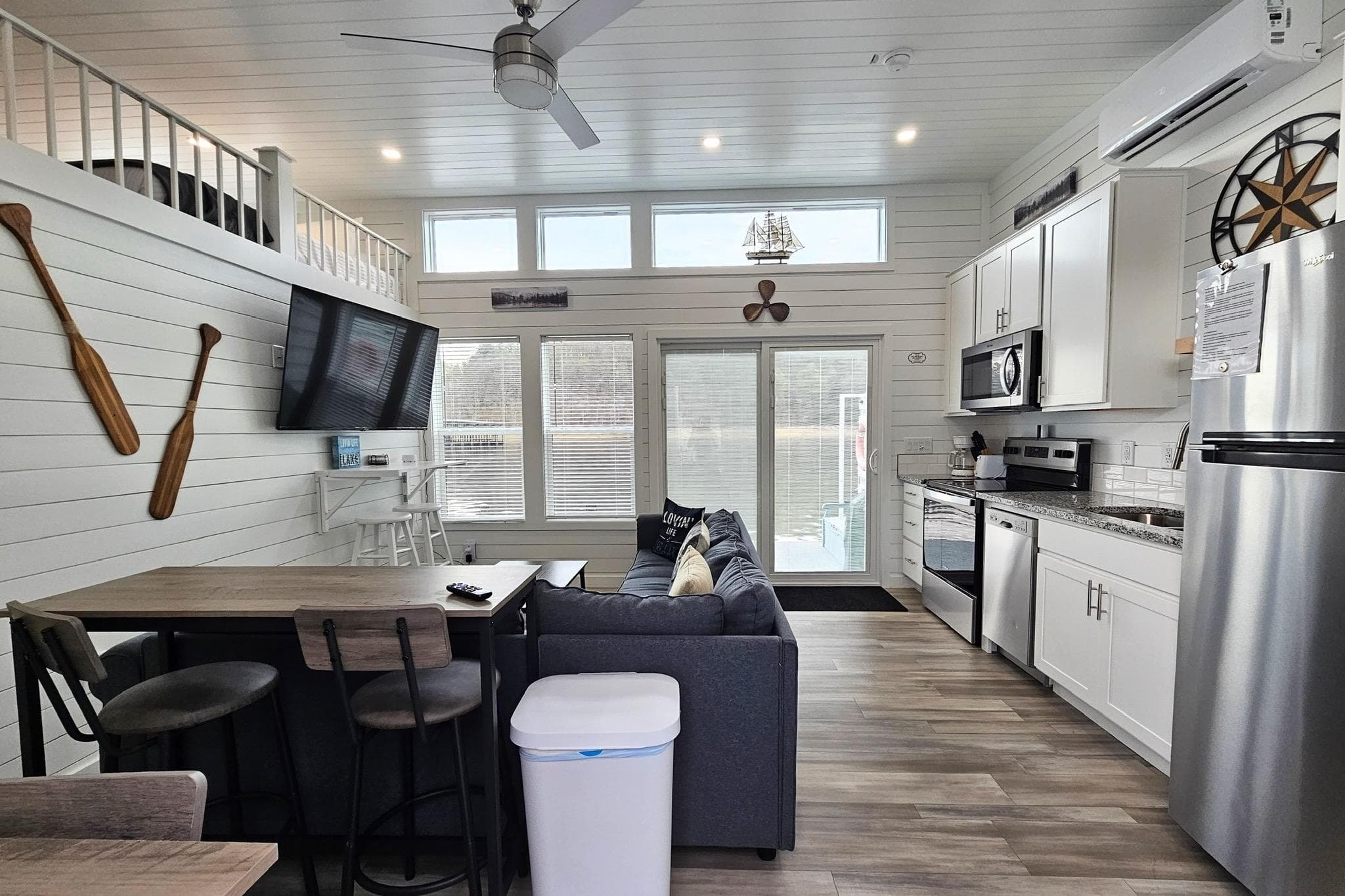 Modern 2025 houseboat interior with kitchen, living area, and nautical decor.