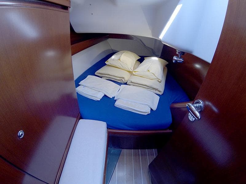 Cozy cabin interior of 2010 Grand Soleil 37 yacht with neatly arranged bedding.