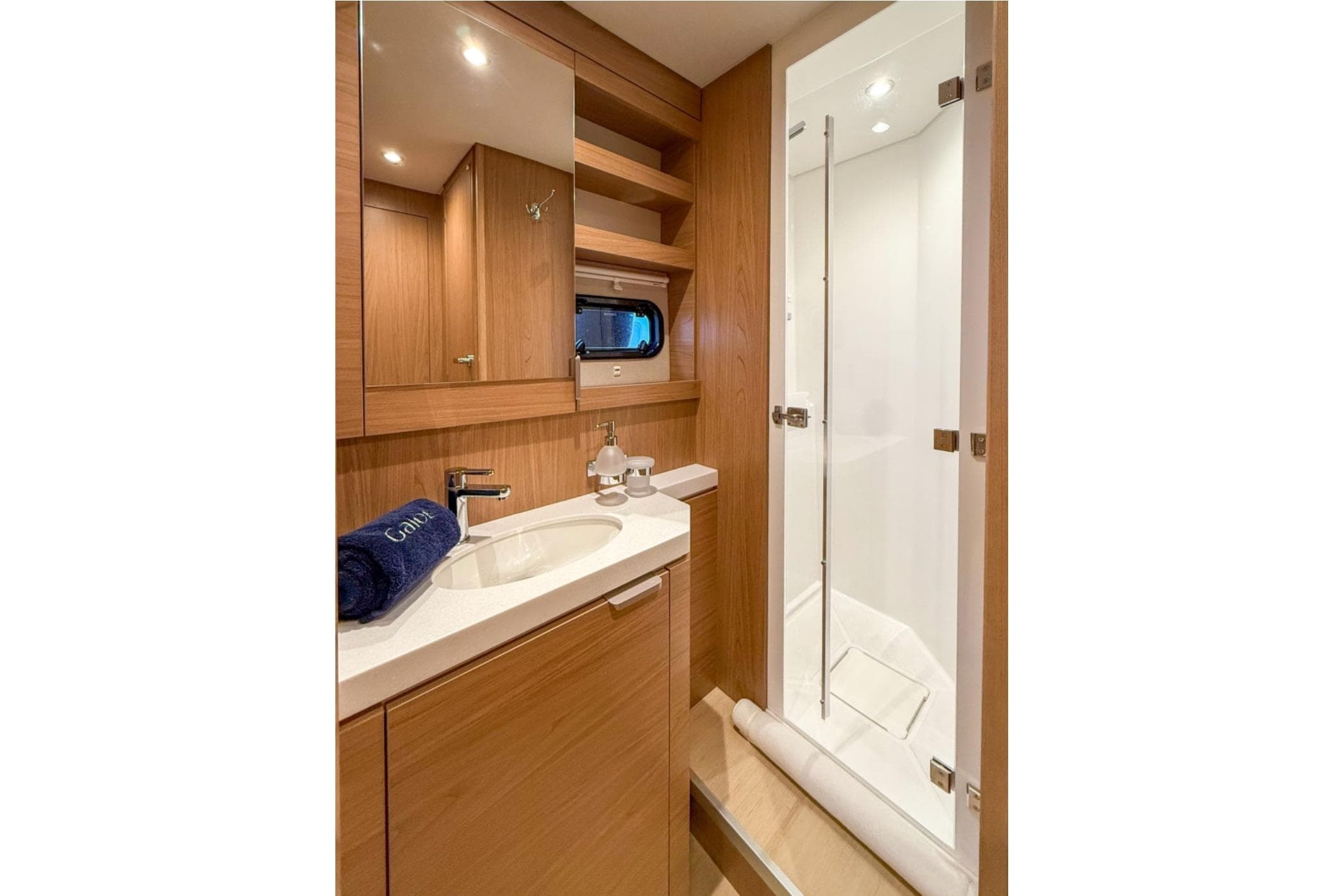 Luxurious 2023 Bali 5.4 yacht bathroom with modern wood finish and sleek shower.