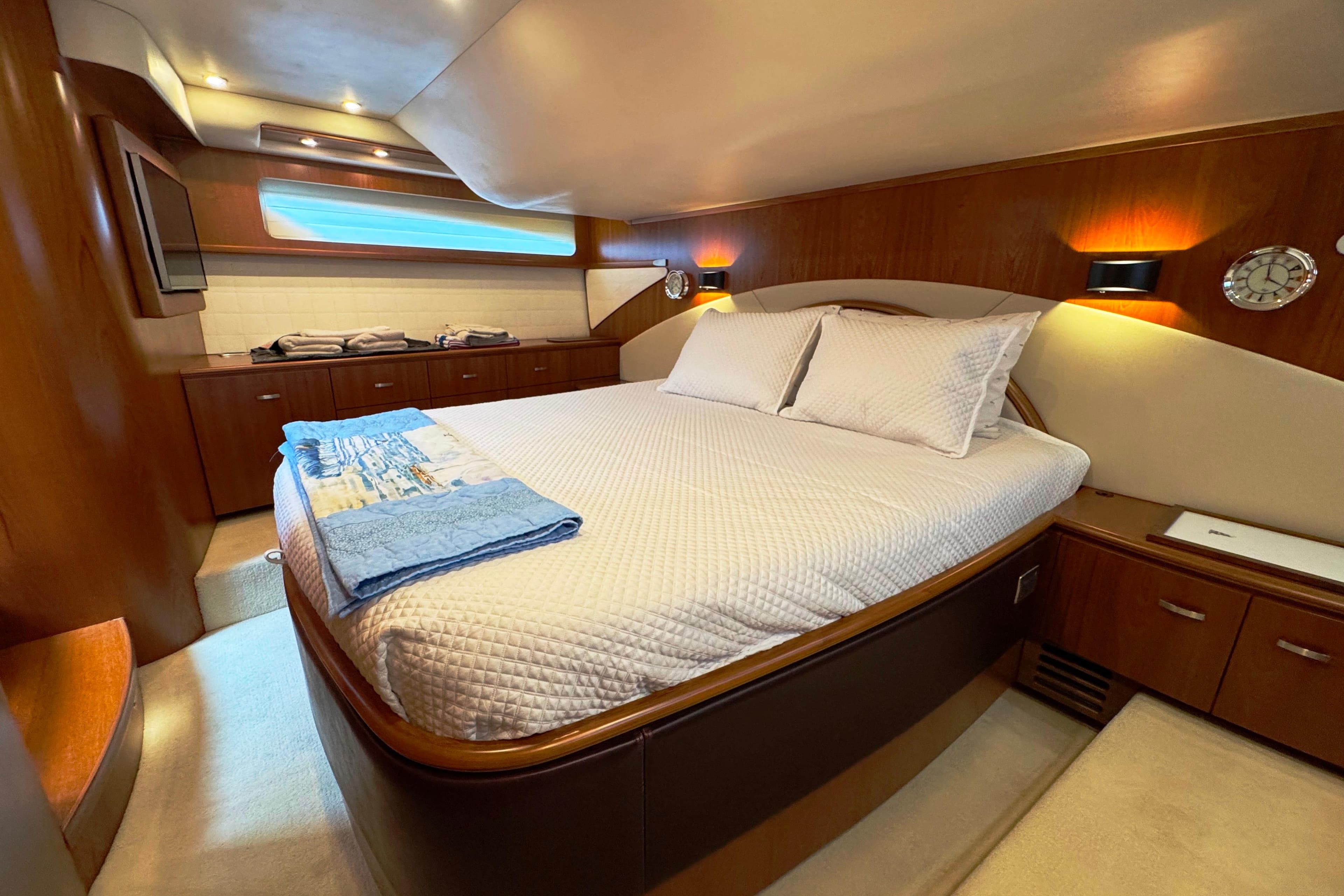 Luxurious bedroom interior of 2014 Tiara Yachts 5800 Sovran with elegant wood finishes.