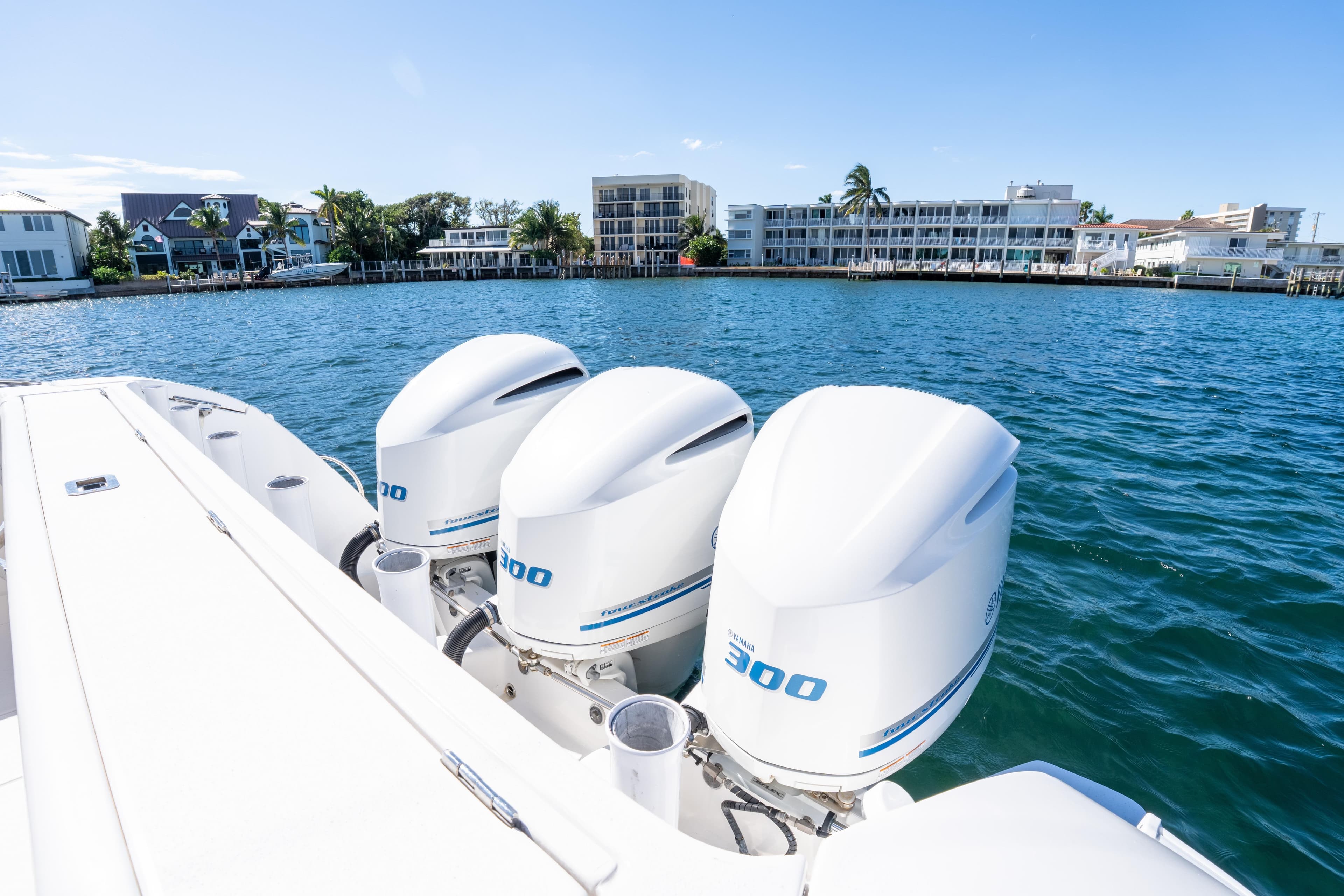 2019 Intrepid 407 Cuddy boat with triple Yamaha 300 engines on a sunny waterfront.