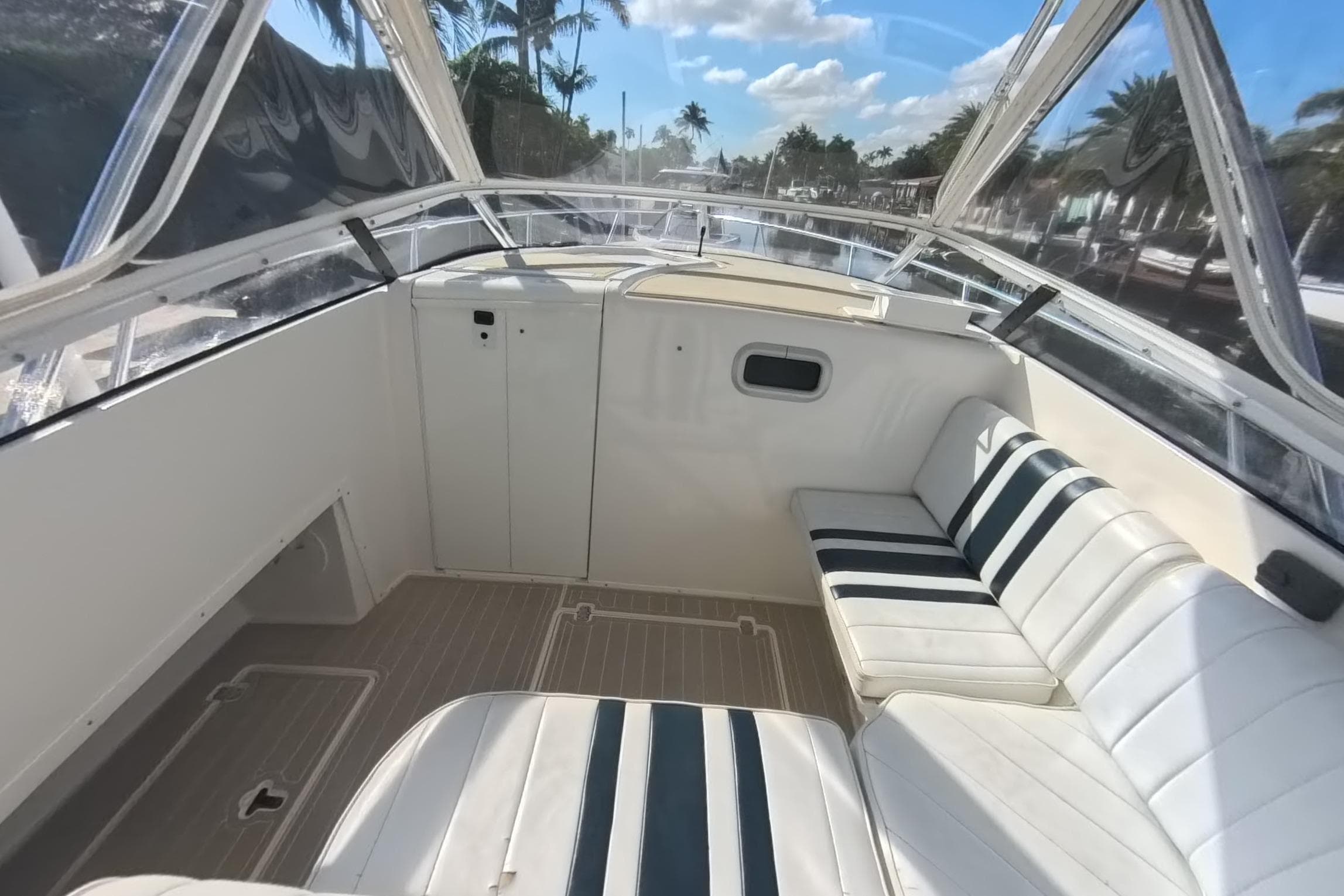 2005 Intrepid 348 Walkaround boat interior with white seating and clear canopy.