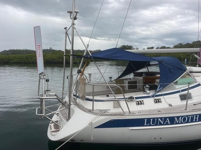 2003 Hallberg-Rassy 34 sailboat "Luna Moth" docked with blue canopy.