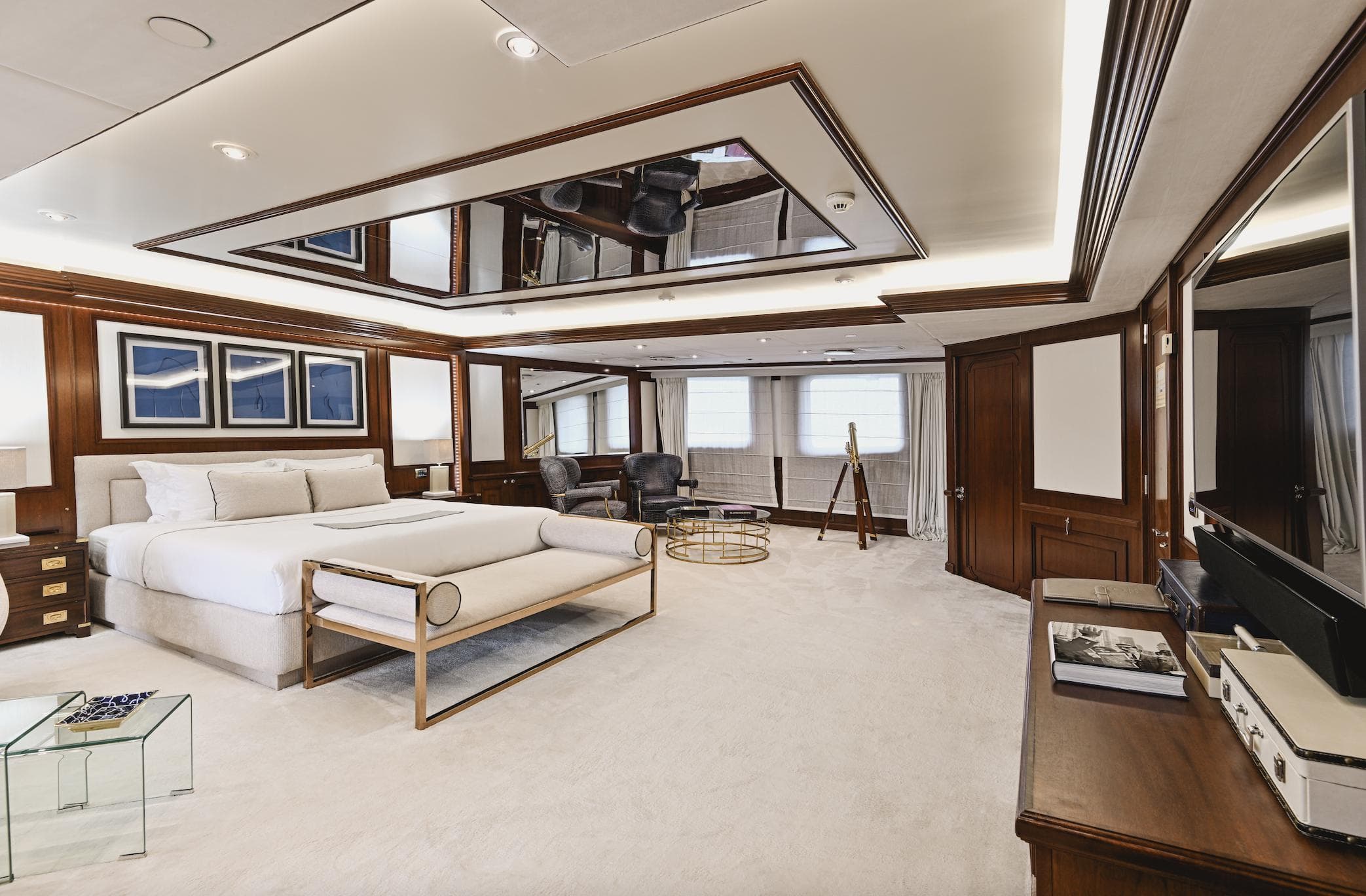 Luxurious yacht bedroom with elegant decor, featuring a large bed, wooden accents, and modern furnishings.