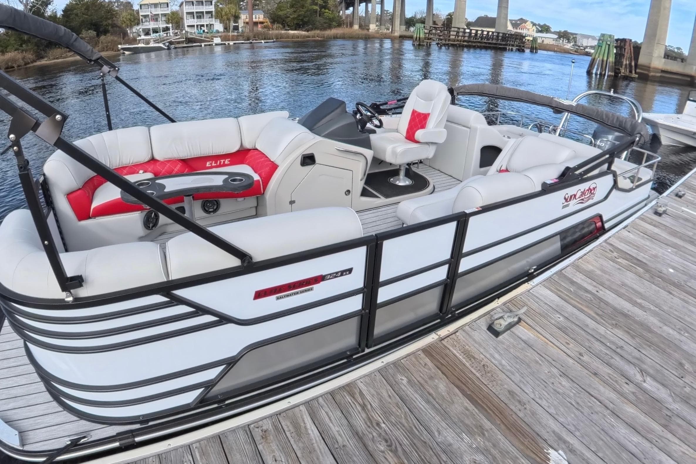 2025 SunCatcher ELITE SERIES 324 SS pontoon boat docked by the water.