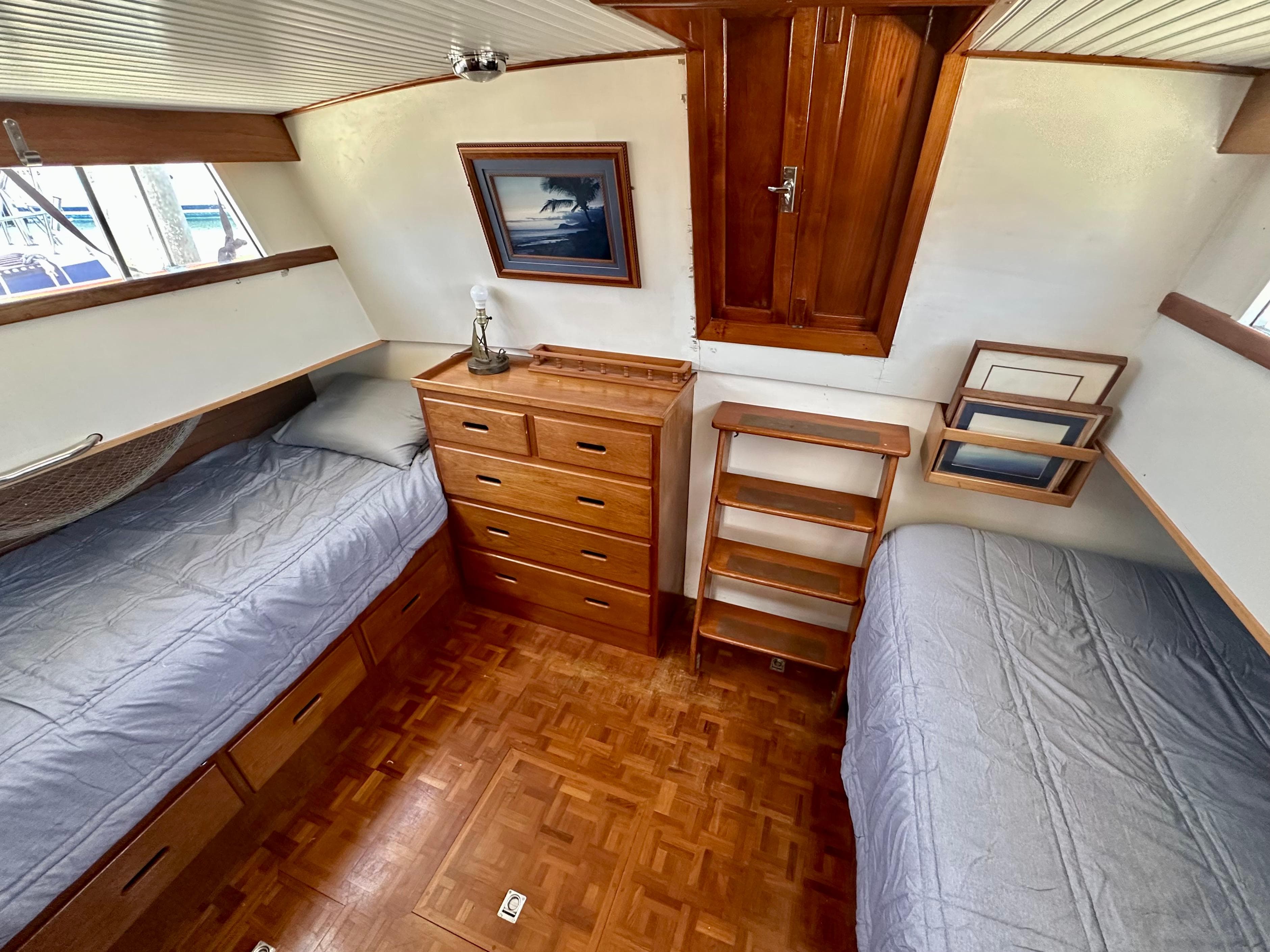 1977 Grand Banks 42 Classic cabin with twin beds, wooden drawers, and nautical decor.