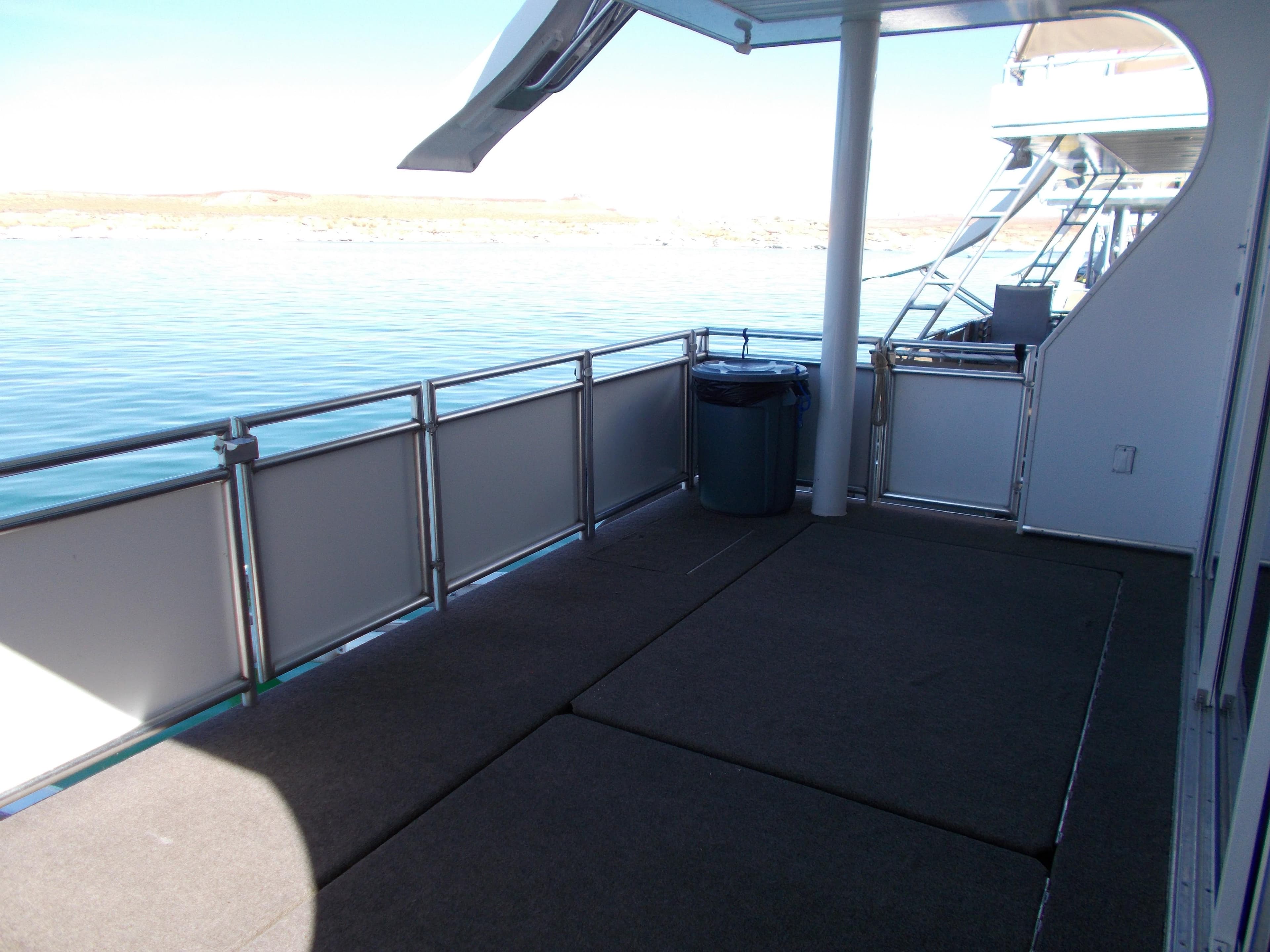 Deck of a 2015 Bravada Intrepid Trip #13 houseboat with lake view.