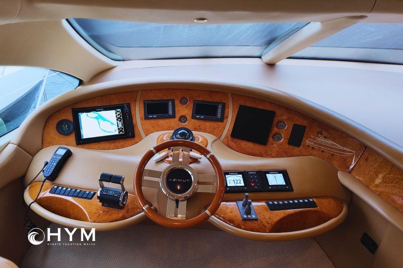 Luxurious 2007 Azimut 68E yacht helm with advanced navigation controls and elegant wood finish.