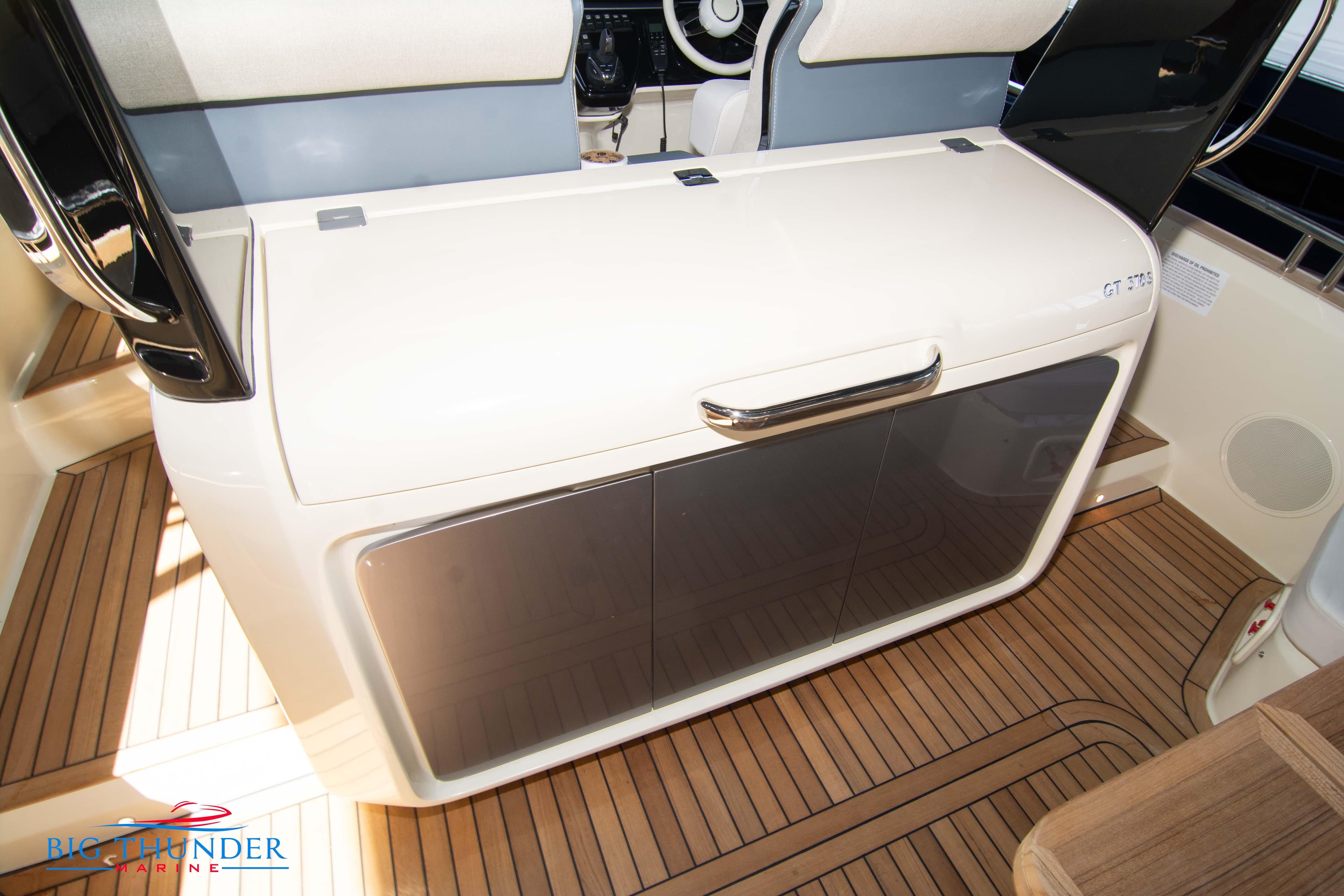 2024 Invictus GT370S yacht interior with sleek cabinetry and wooden flooring.