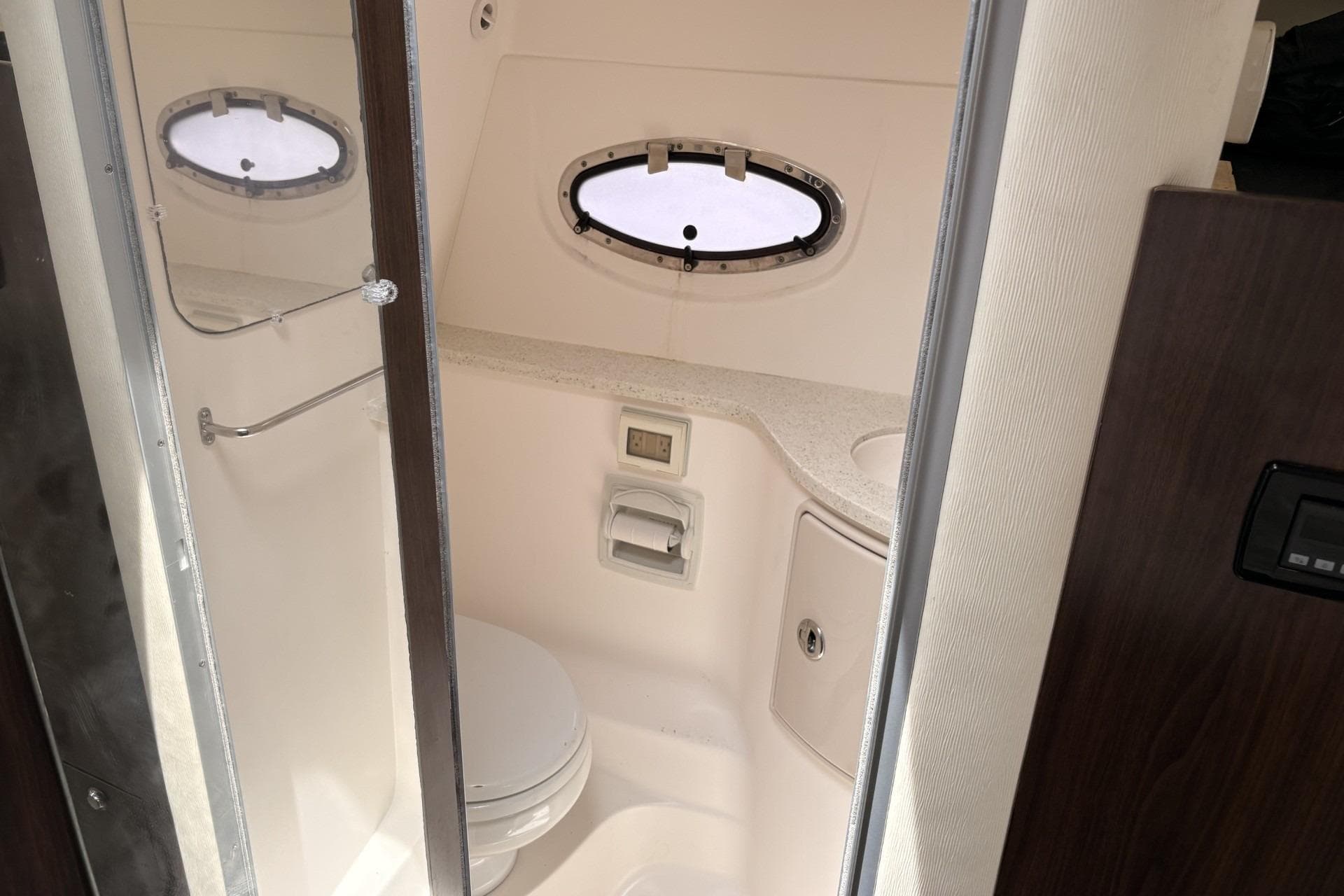 2016 Regal 30 Express boat bathroom with porthole window and compact design.