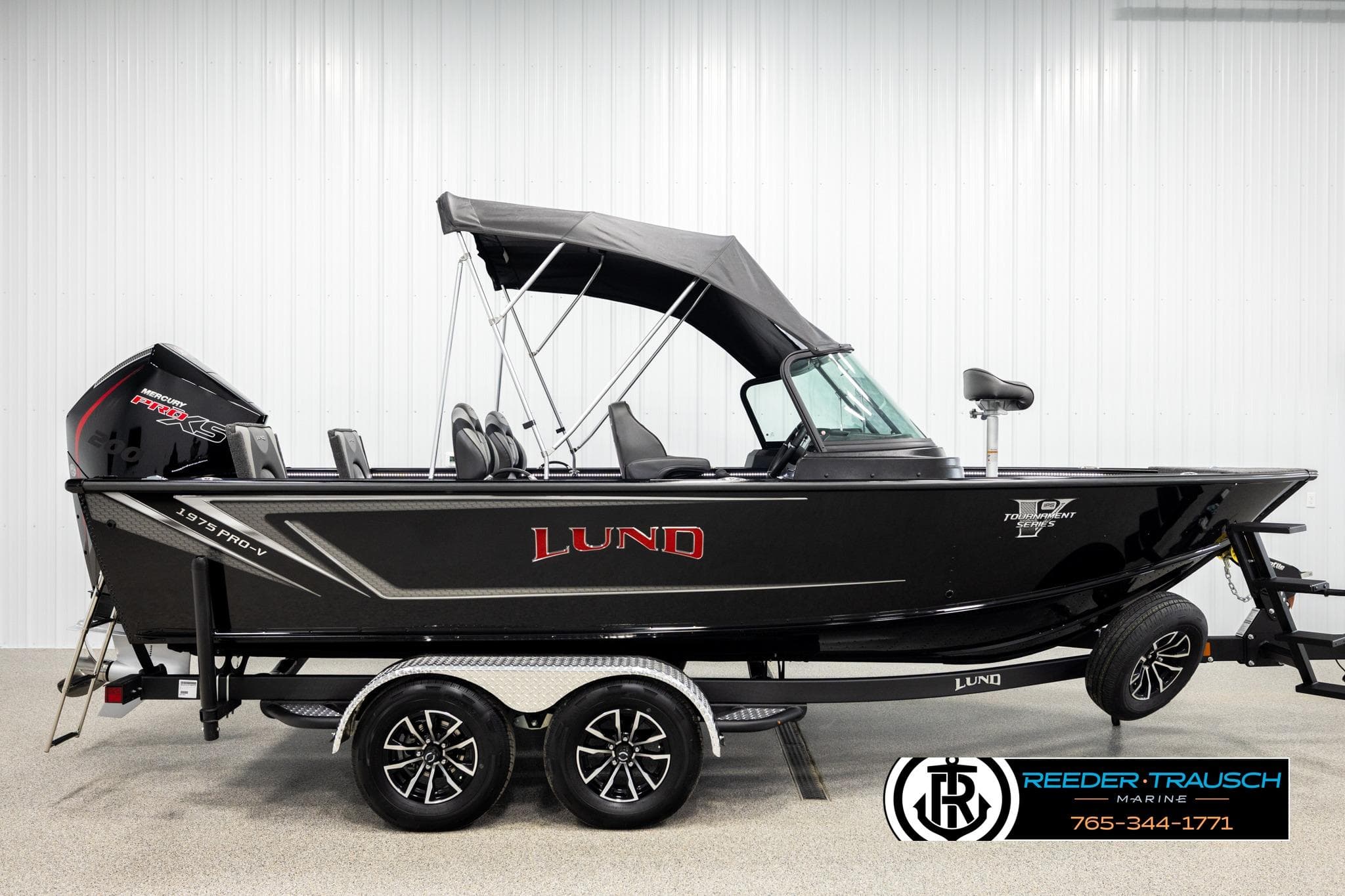 2026 Lund 1975 Pro-V Sport boat with black exterior and canopy on a trailer.