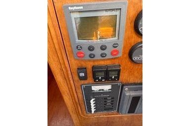 Control panel of 2001 Logan 33 boat with Raytheon display and switches.