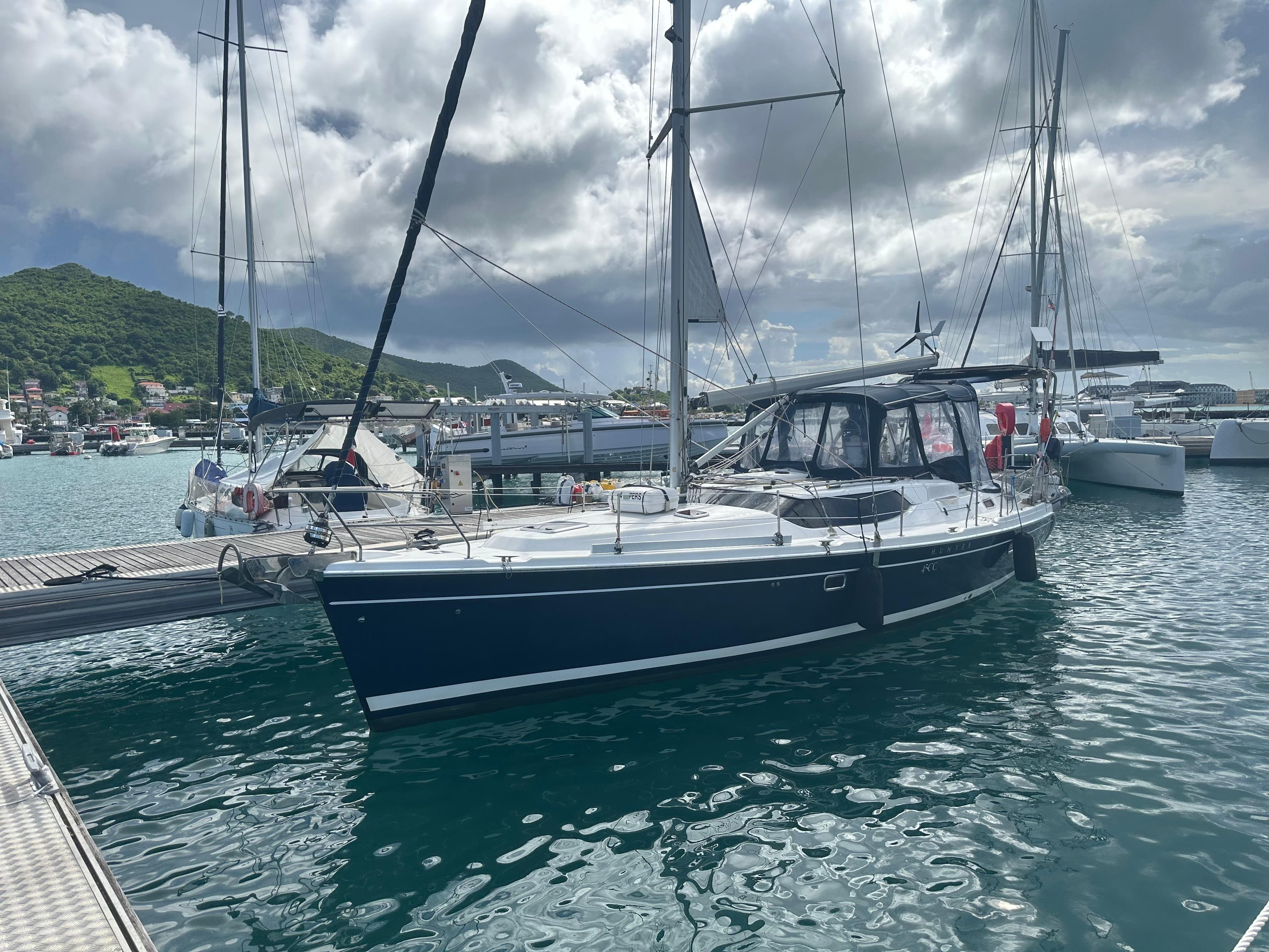 Sailboat docked in marina, 2006 Hunter 45cc, under cloudy sky.