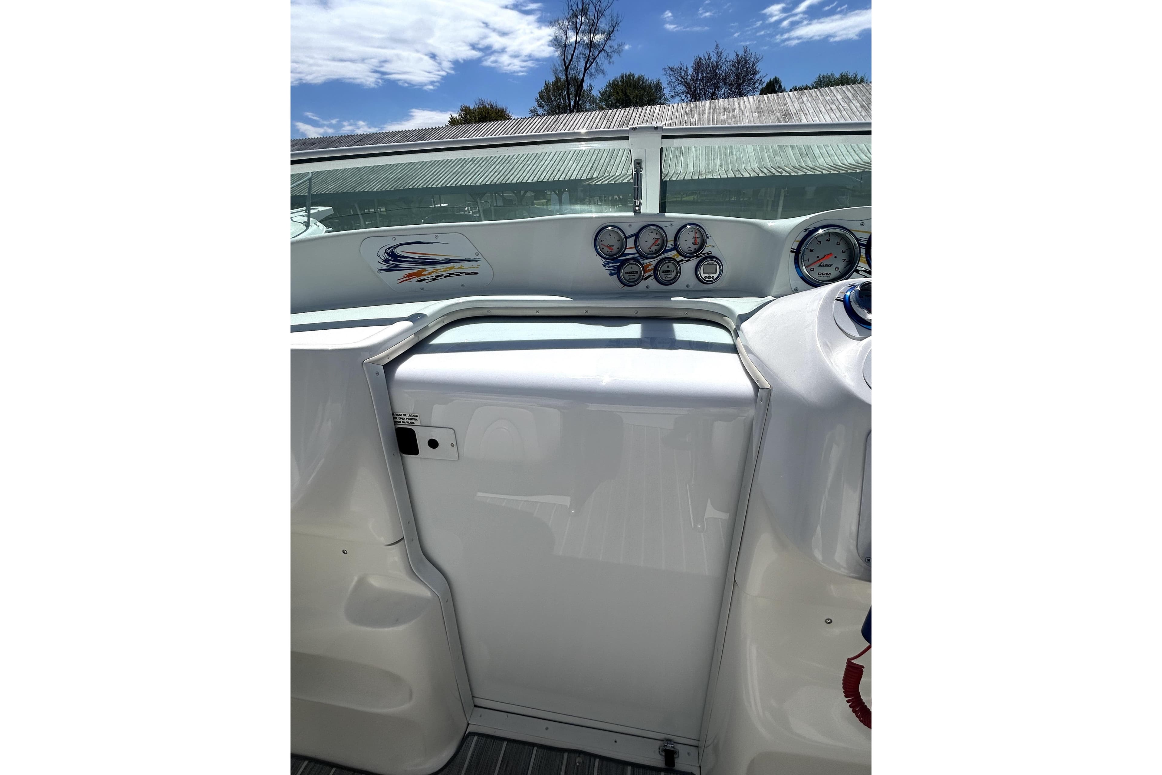 2007 Sunsation 32 Dominator boat dashboard with gauges under a clear sky.