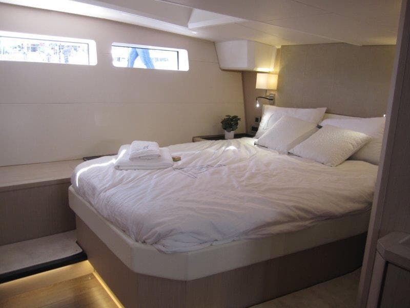 Luxurious bedroom interior of 2024 Jeanneau 60 yacht with modern design and cozy bedding.