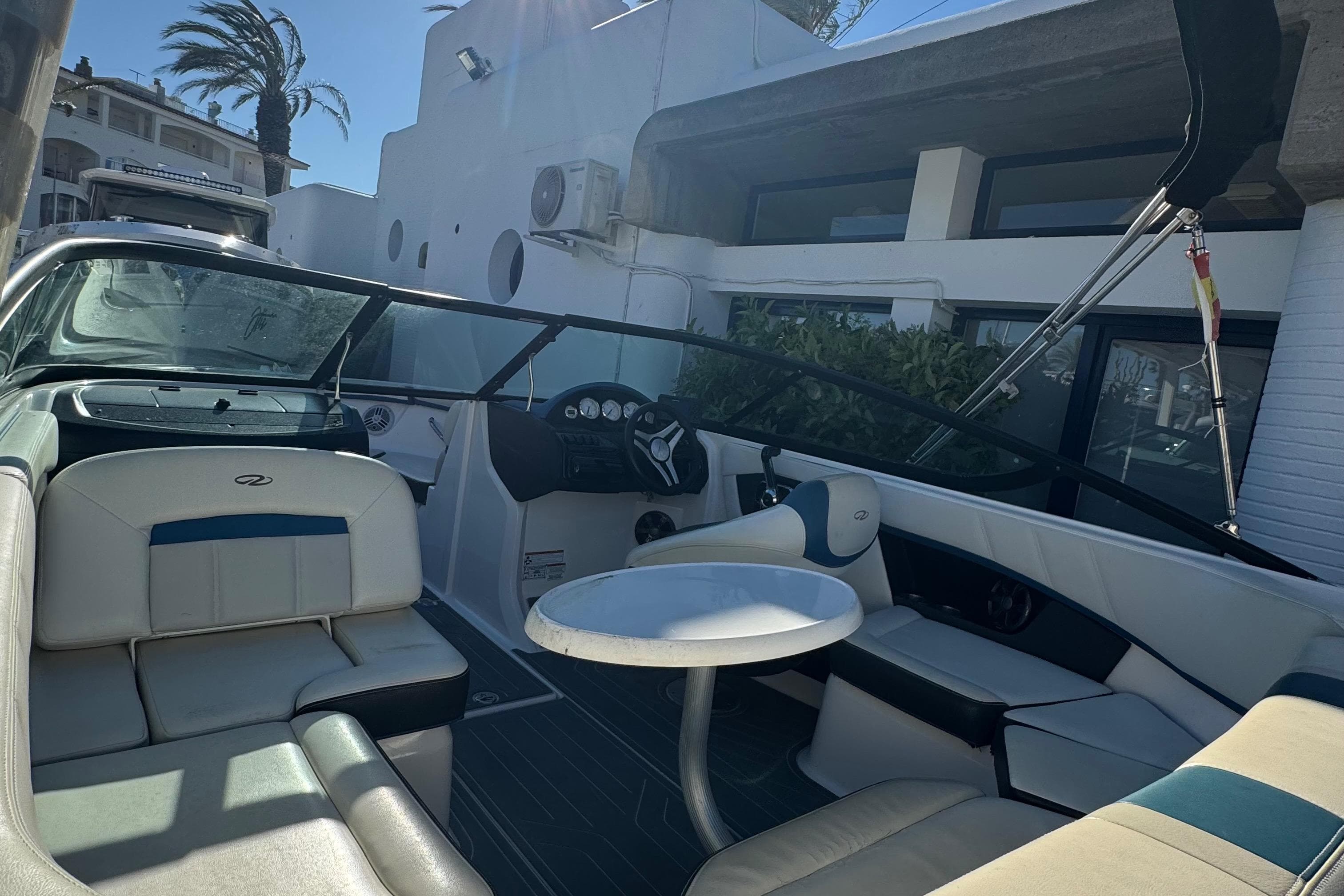 2016 Regal 2000 ESX Bowrider interior with seating and table, docked near a building.