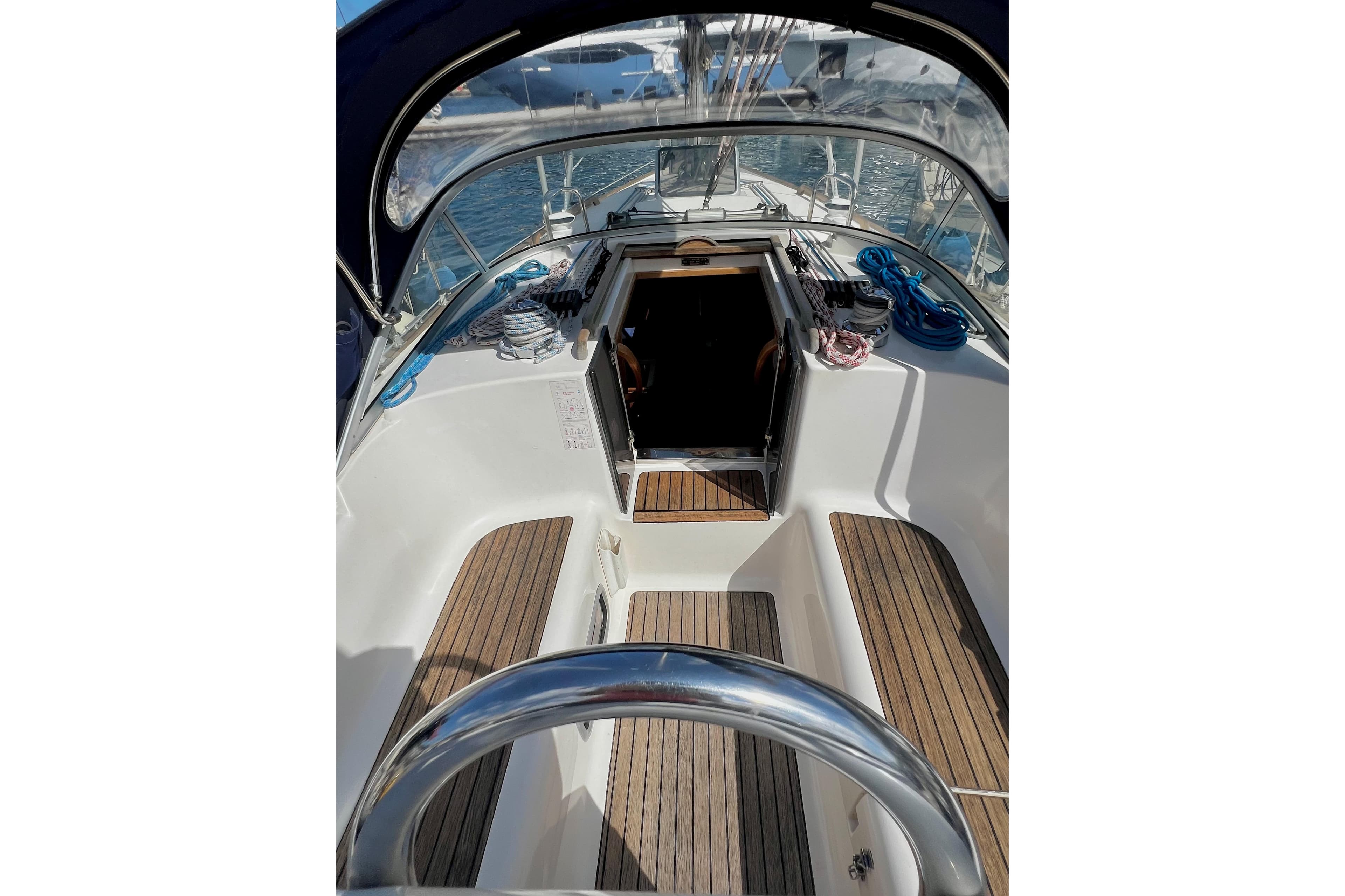 Cockpit view of 2004 Adria Event 34 sailboat with wooden deck and steering wheel.