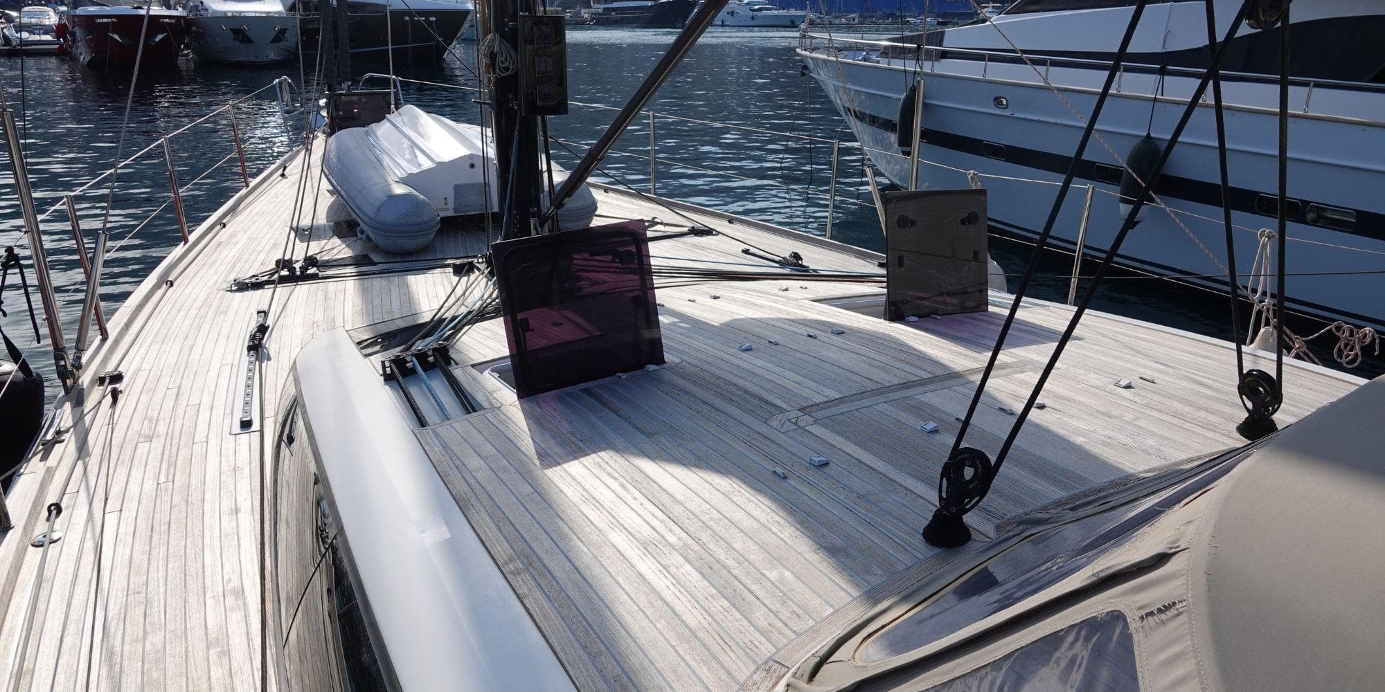 Sleek CNB BORDEAUX 60 yacht deck, 2012 model, docked in a marina.