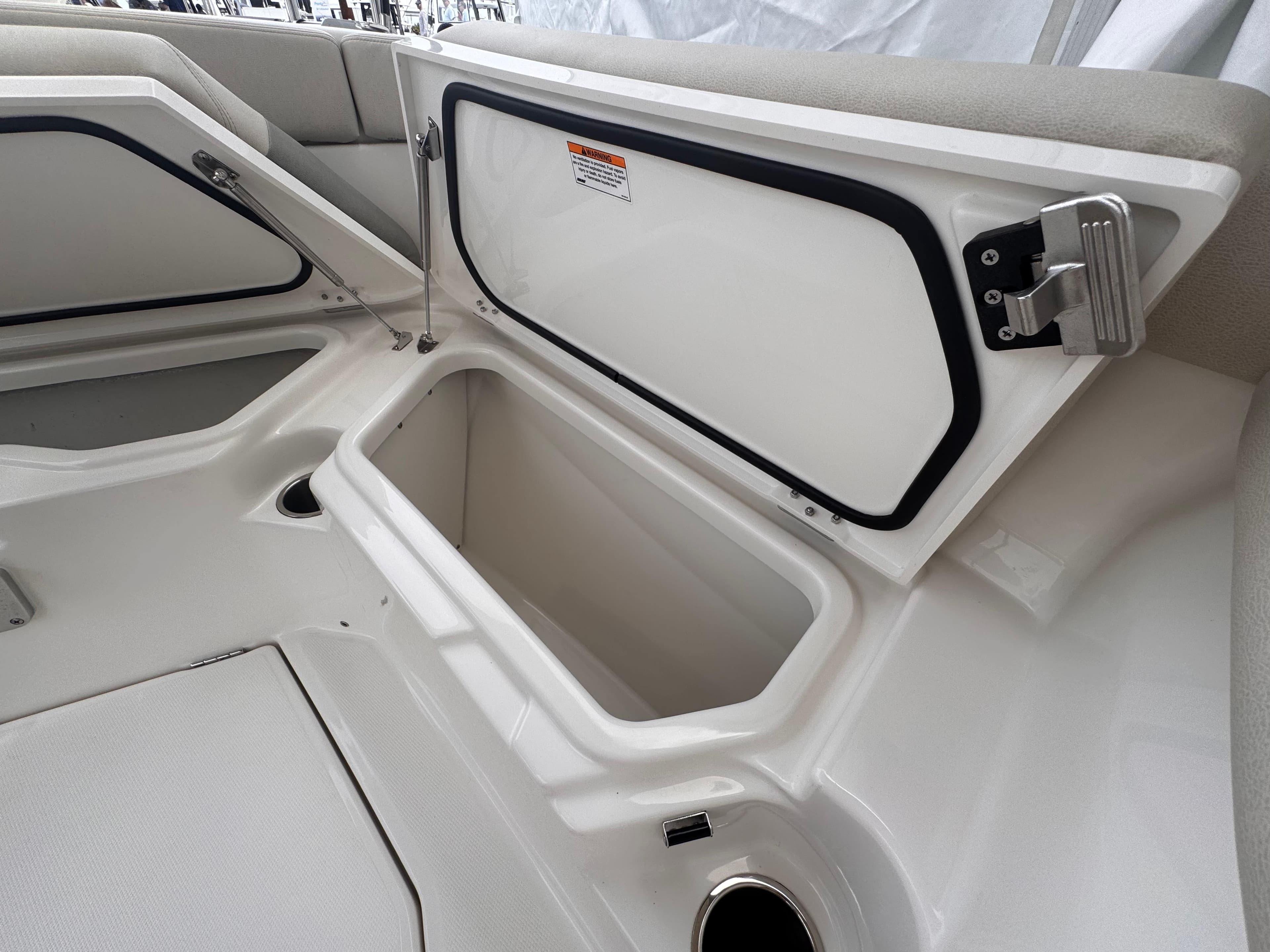 Open storage compartment on a 2025 Solace 30 CS boat, showcasing interior space.