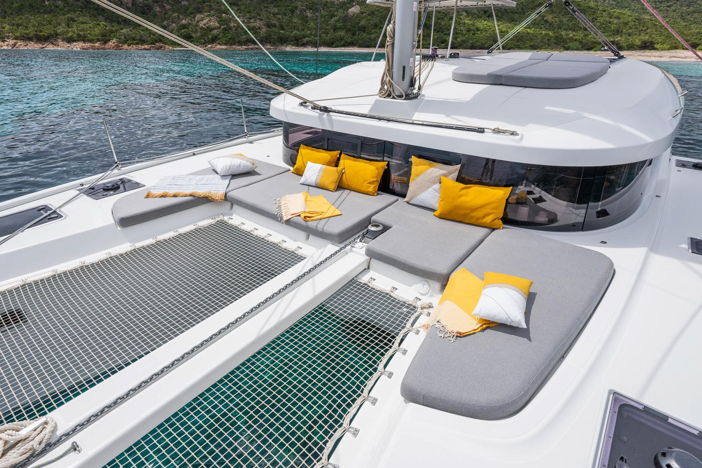 Luxurious Lagoon 38 catamaran deck with cushions, 2025 model, anchored in serene waters.