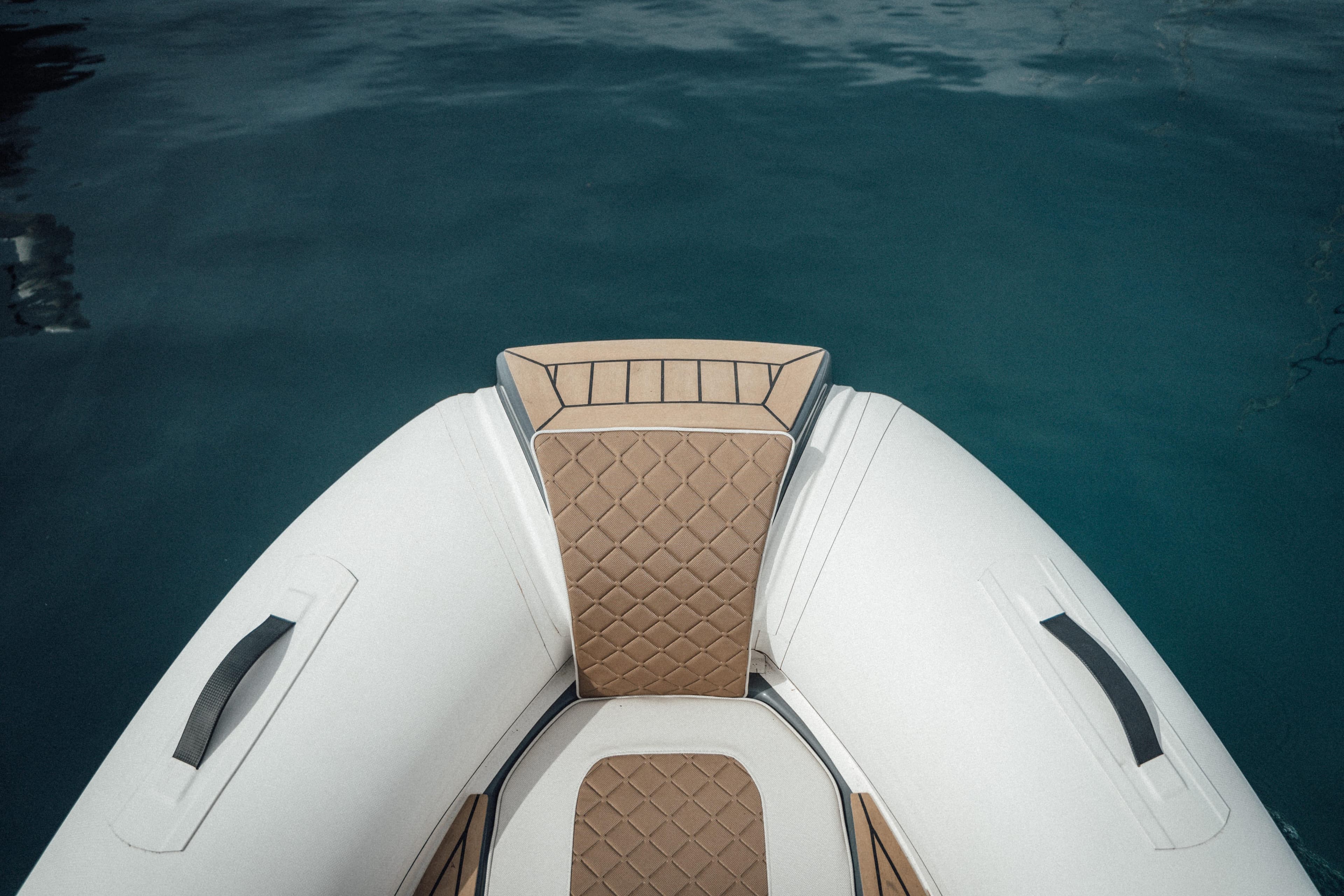 Ejet 4X 2026 inflatable boat with tan quilted seating on calm water.